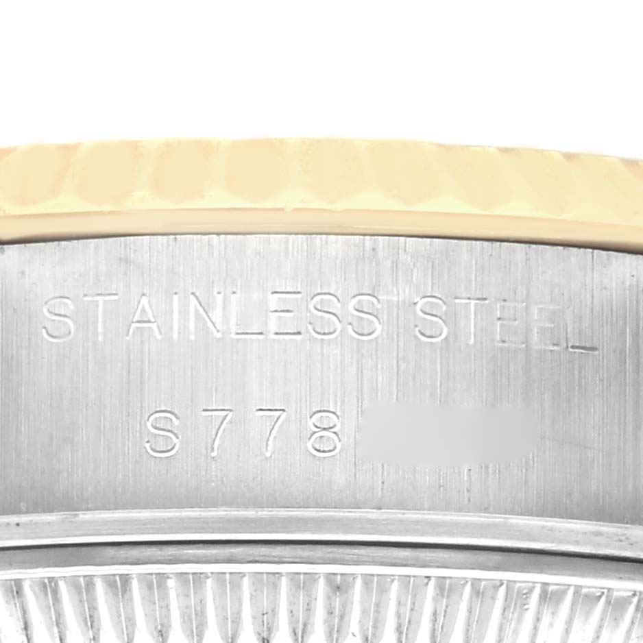 The image shows a close-up of the side edge of a Rolex Datejust 69173 Women
s Steel and Gold (two tone) Black Dial 69173 Women
s Steel and Gold (two tone) Black Dial
s stainless steel watch case with engraved details.