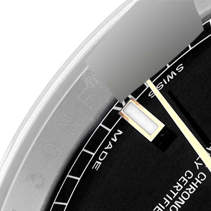This close-up image of the Rolex Datejust 116233 Men's Steel and Gold (two tone) Black Dial 116233 Men's Steel and Gold (two tone) Black Dial watch shows part of the dial, edge of the bezel, and part of the "SWISS MADE" marking.