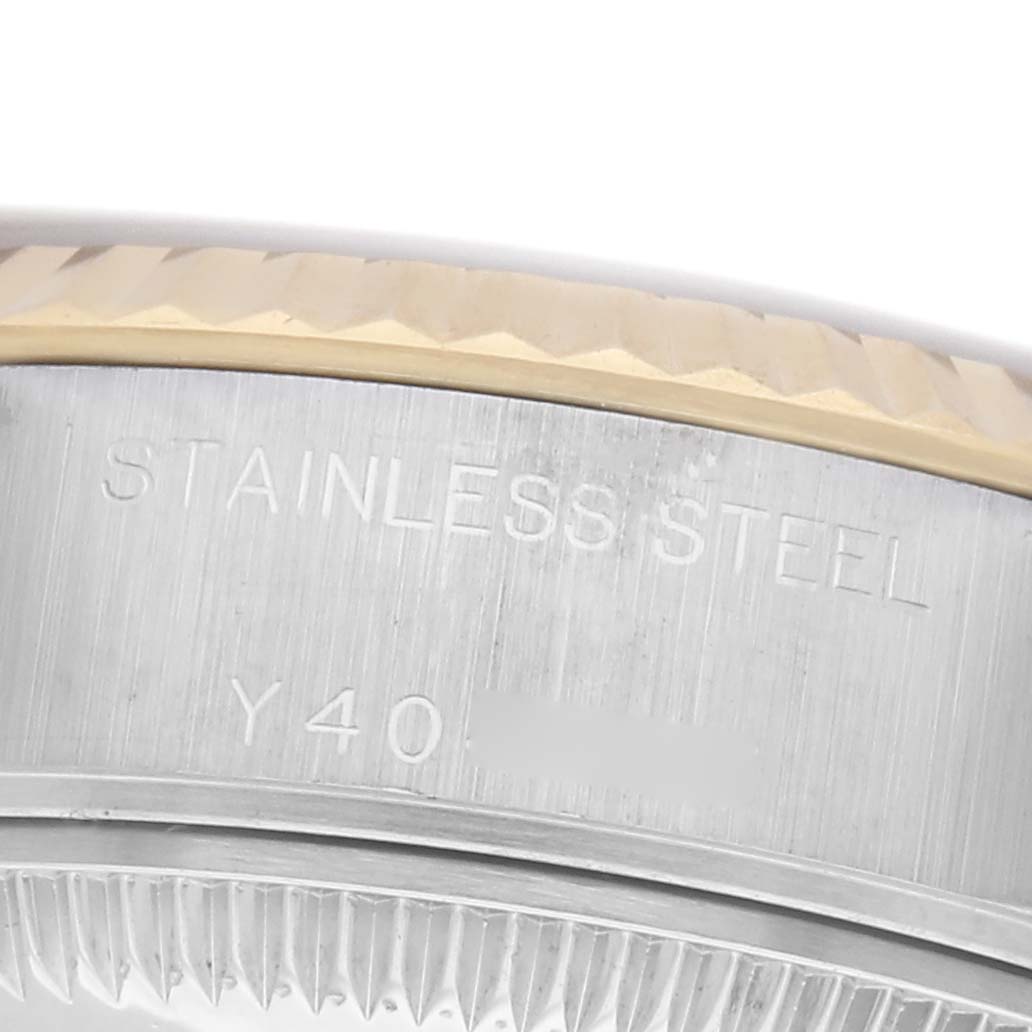 The image shows a close-up of the side engraving on the stainless steel case of a Rolex Datejust 79173 Women
s Steel and Gold (two tone) Champagne Dial 79173 Women
s Steel and Gold (two tone) Champagne Dial, featuring part of the fluted bezel.
