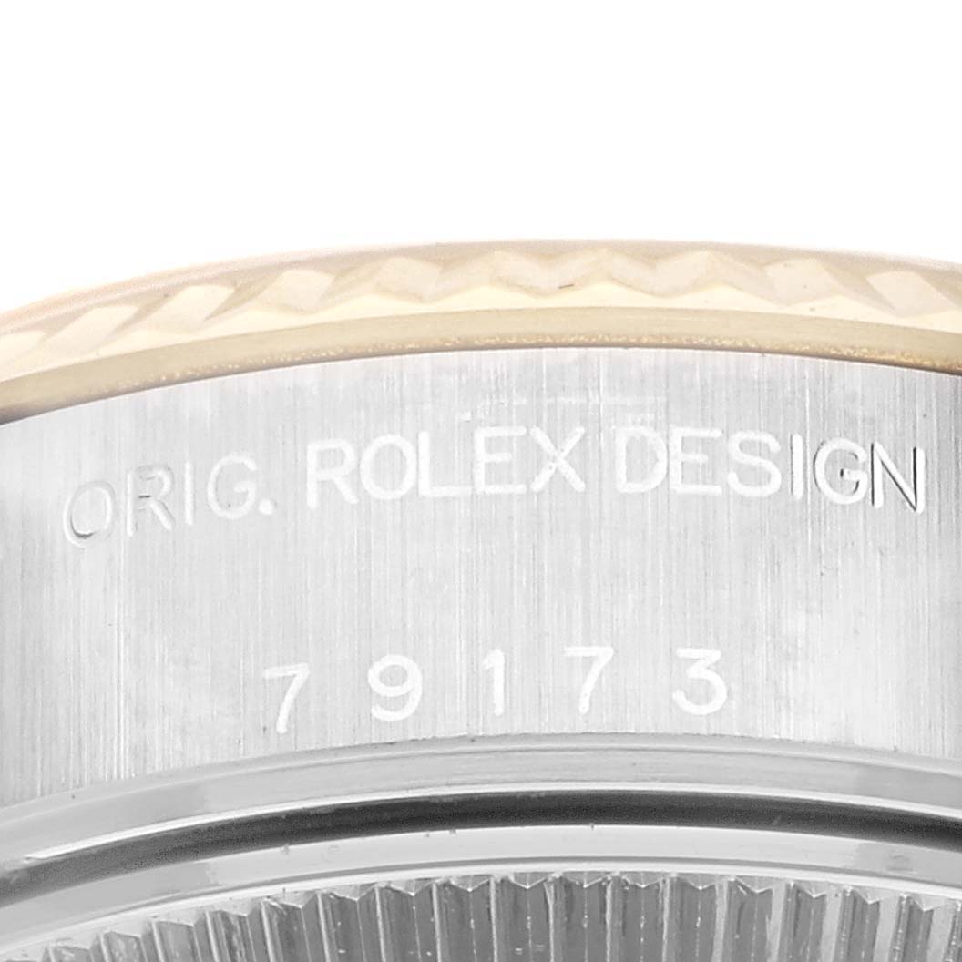 This image shows a close-up of the case side of a Rolex Datejust 79173 Women's Steel and Gold (two tone) Champagne Dial 79173 Women's Steel and Gold (two tone) Champagne Dial, highlighting the engraved text and partial bezel.