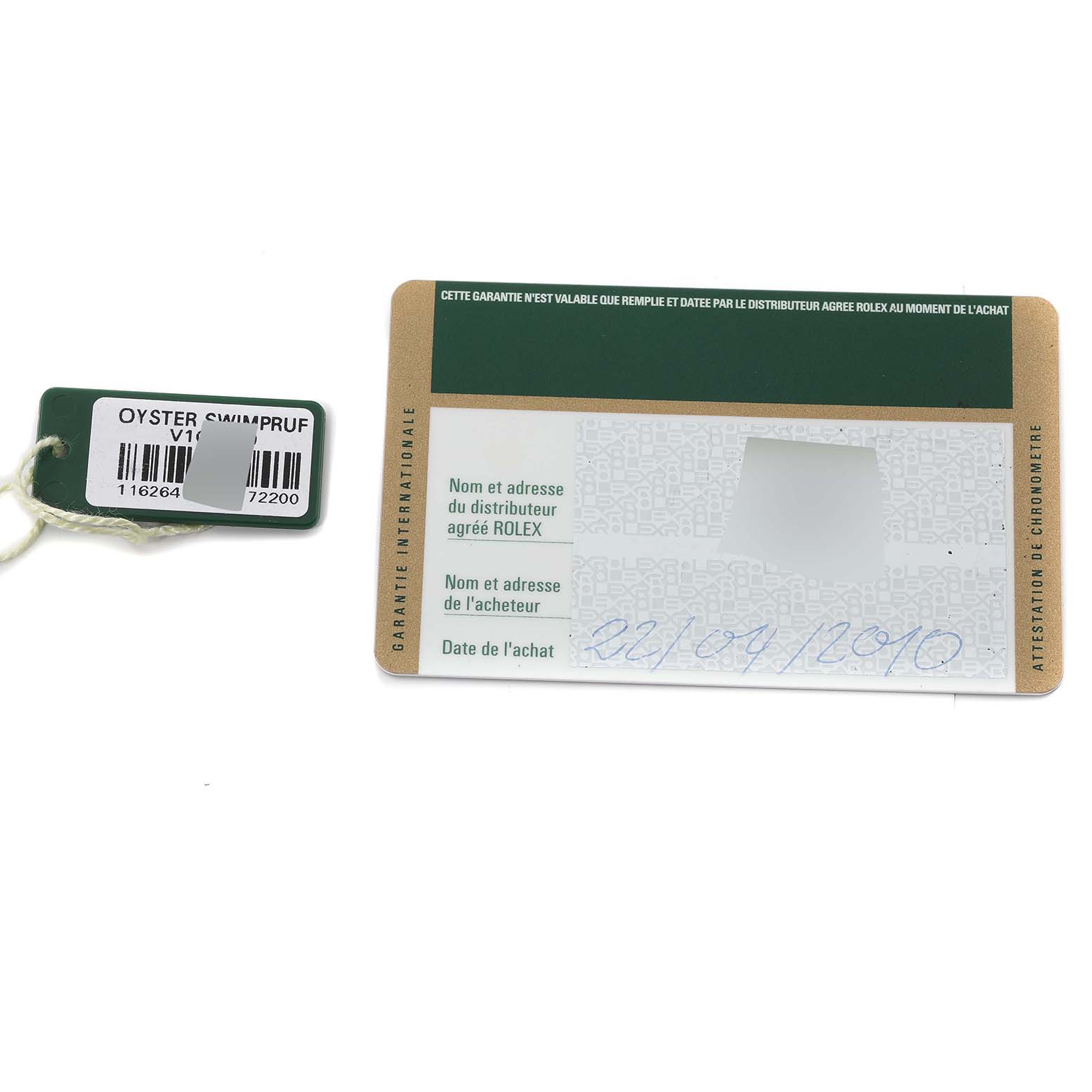 Pictured are a warranty card and a tag for the Rolex Turn-o-Graph 116264 Men's Stainless Steel White Dial 116264 Men's Stainless Steel White Dial watch, shown from a top-down angle.