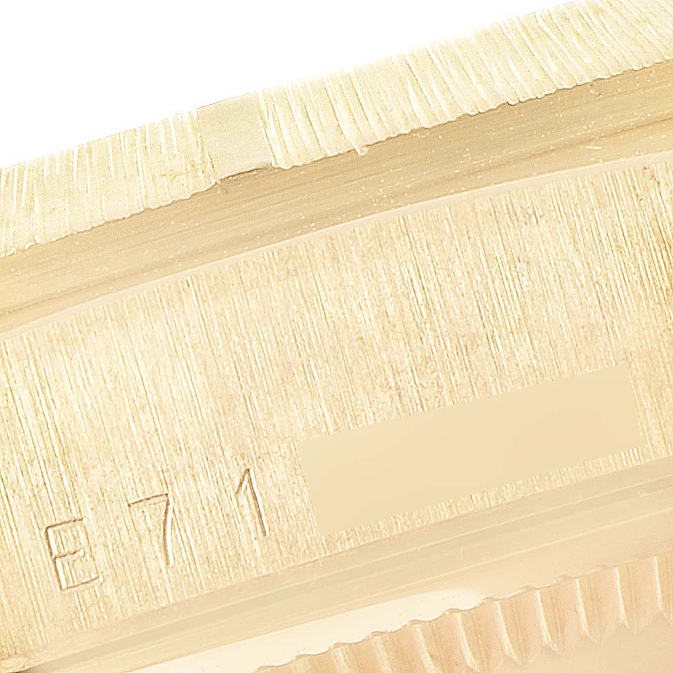 This close-up image of a Rolex President 18248 Men
s Yellow Gold Champagne Dial 18248 Men
s Yellow Gold Champagne Dial model shows part of the fluted bezel and the engraved serial number.