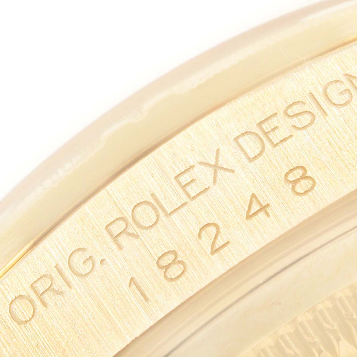 This close-up image shows the Rolex President 18248 Men
s Yellow Gold Champagne Dial 18248 Men
s Yellow Gold Champagne Dial watch model
s engraved serial number area.