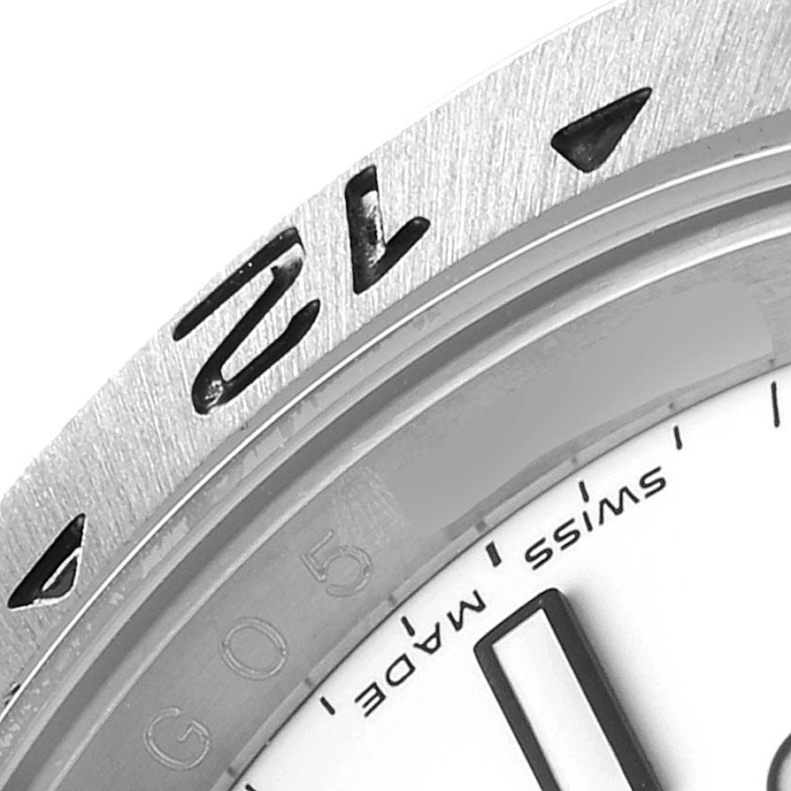 The image shows a close-up angle of the bezel and part of the dial of a Rolex Explorer 16570 Men's Stainless Steel White Dial 16570 Men's Stainless Steel White Dial watch.