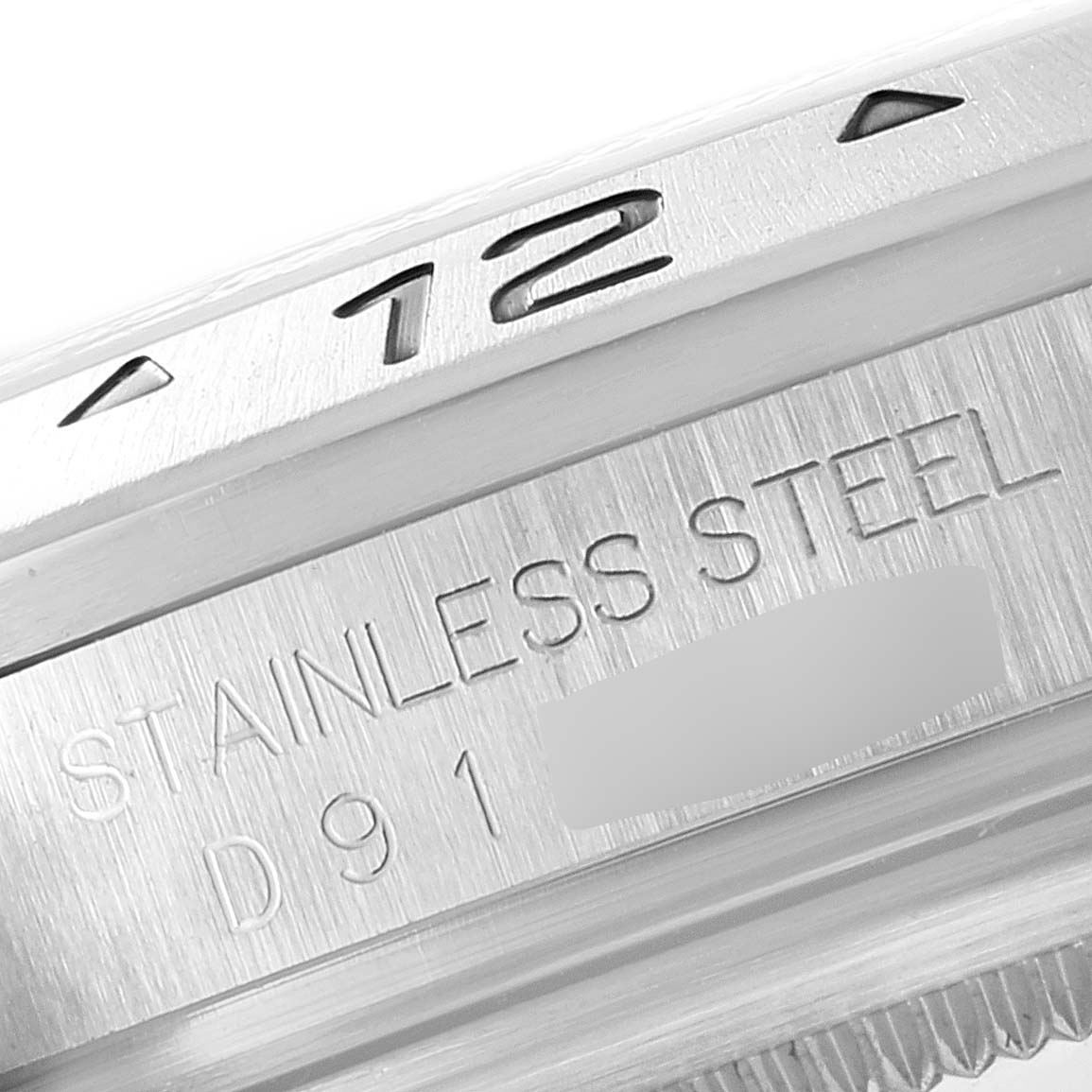 This close-up angle of the Rolex Explorer 16570 Men
s Stainless Steel White Dial 16570 Men
s Stainless Steel White Dial watch shows the bezel and part of the rehaut with "STAINLESS STEEL" engraving.