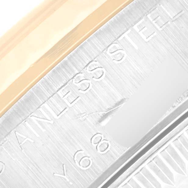 This close-up image shows the brushed stainless steel caseback and part of the bezel of a Rolex Oyster Perpetual 76193 Women's Steel and Gold (two tone) Black Dial 76193 Women's Steel and Gold (two tone) Black Dial watch.