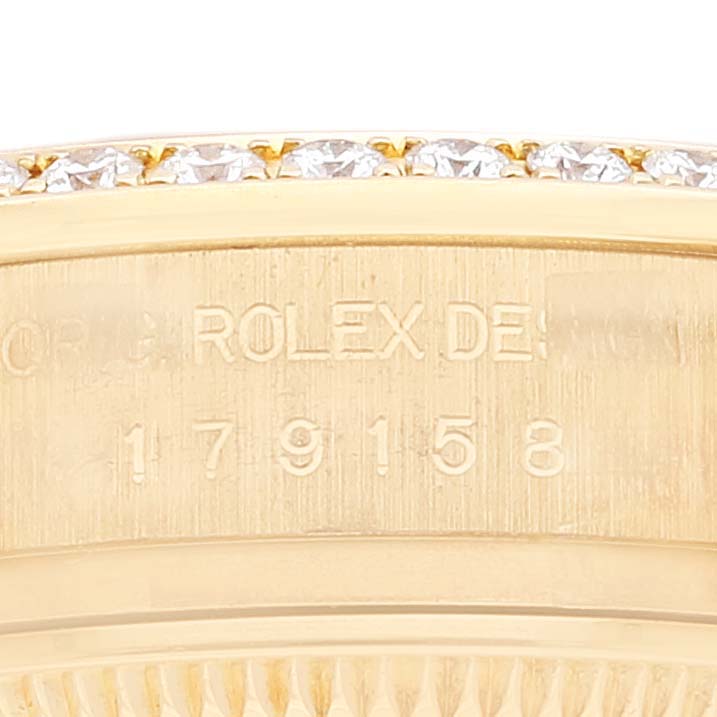 This close-up image shows the engraved case side of a Rolex President 179158 Women's Yellow Gold Champagne Dial 179158 Women's Yellow Gold Champagne Dial model, revealing its serial number.