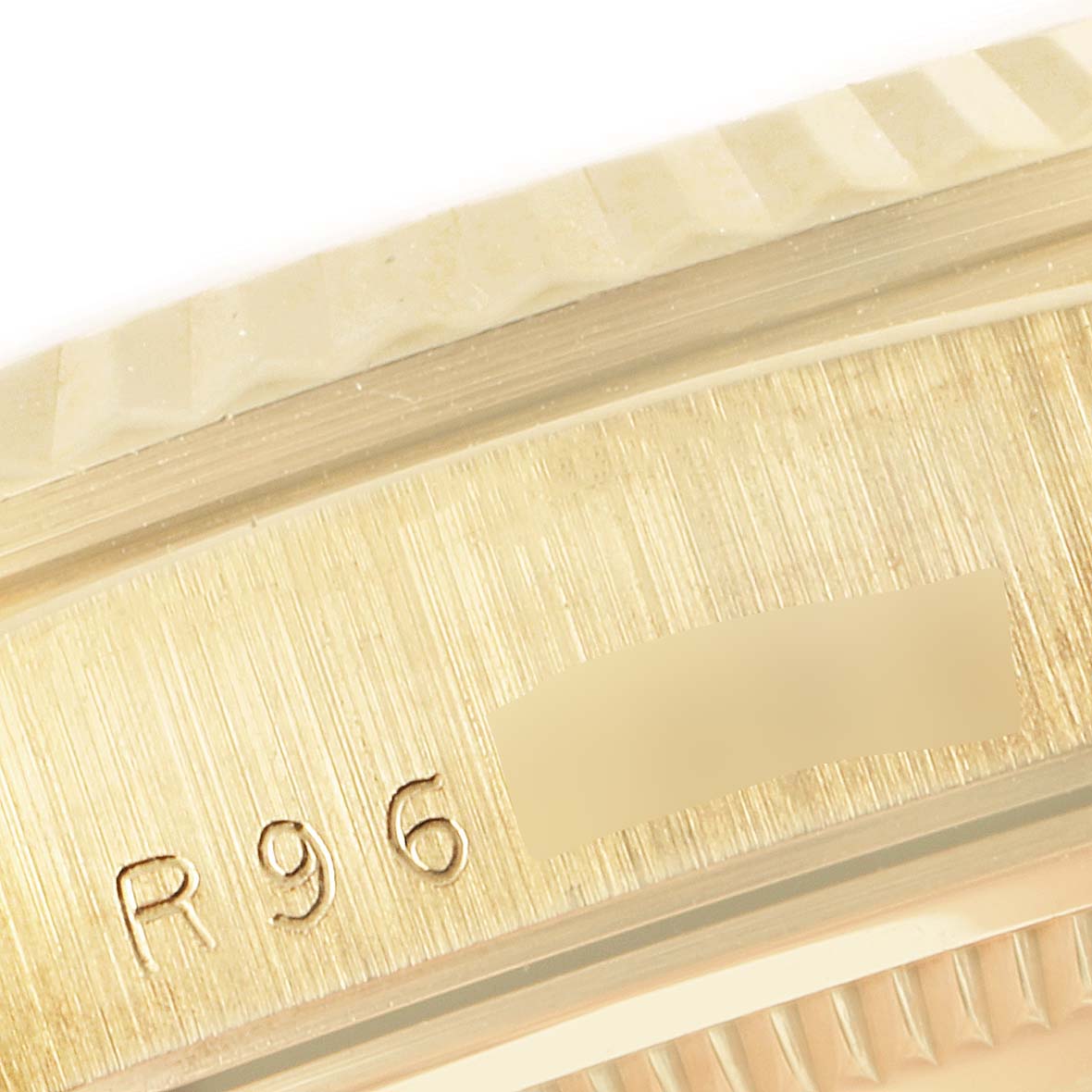 This close-up image shows the edge of the bezel and part of the case engraved with R96 on a Rolex President 18238 Men's Yellow Gold Champagne Dial 18238 Men's Yellow Gold Champagne Dial watch.