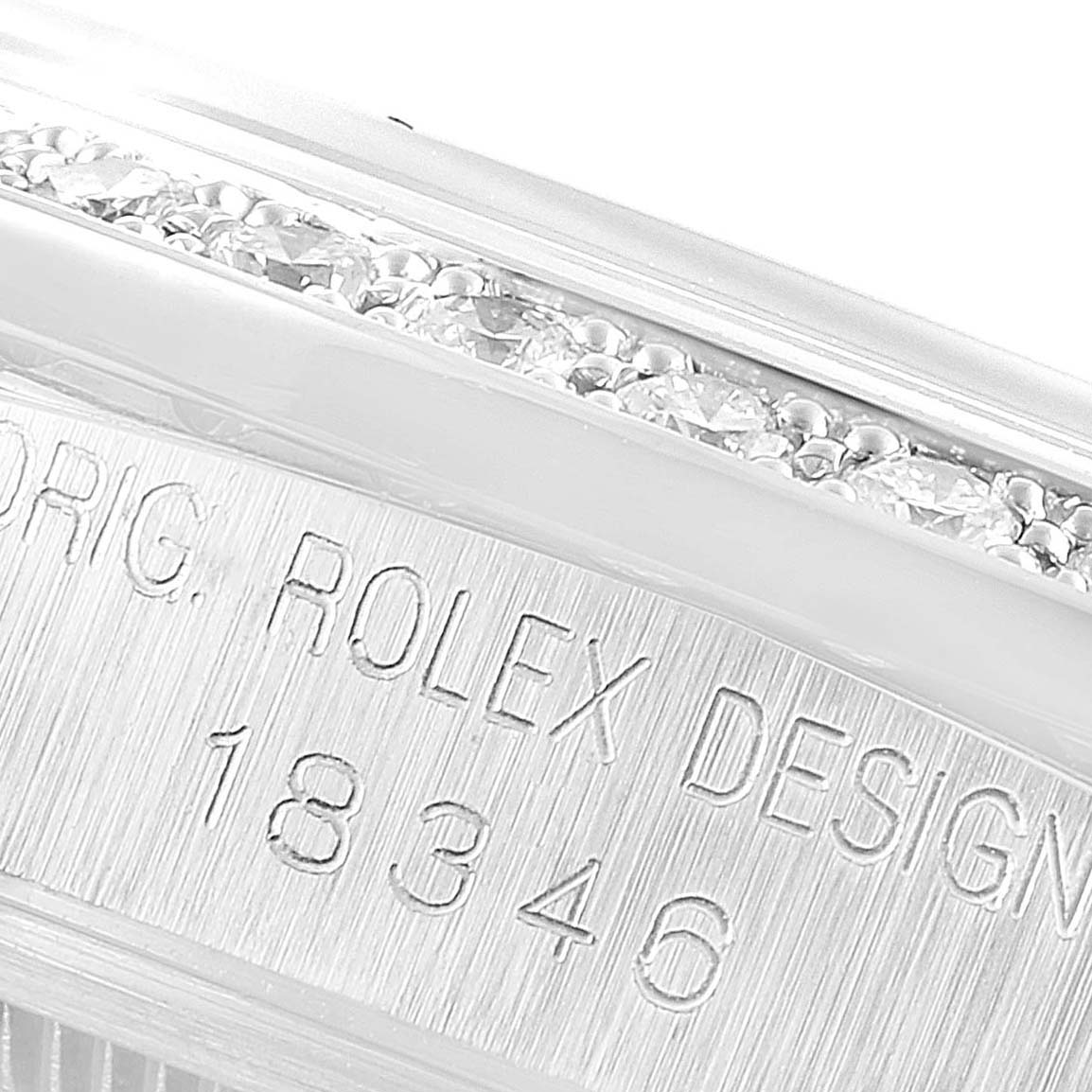 The image shows a close-up of the side of a Rolex President 18346 Men's Platinum Silver Dial 18346 Men's Platinum Silver Dial model watch, highlighting its engraved model number and partially jeweled bezel.