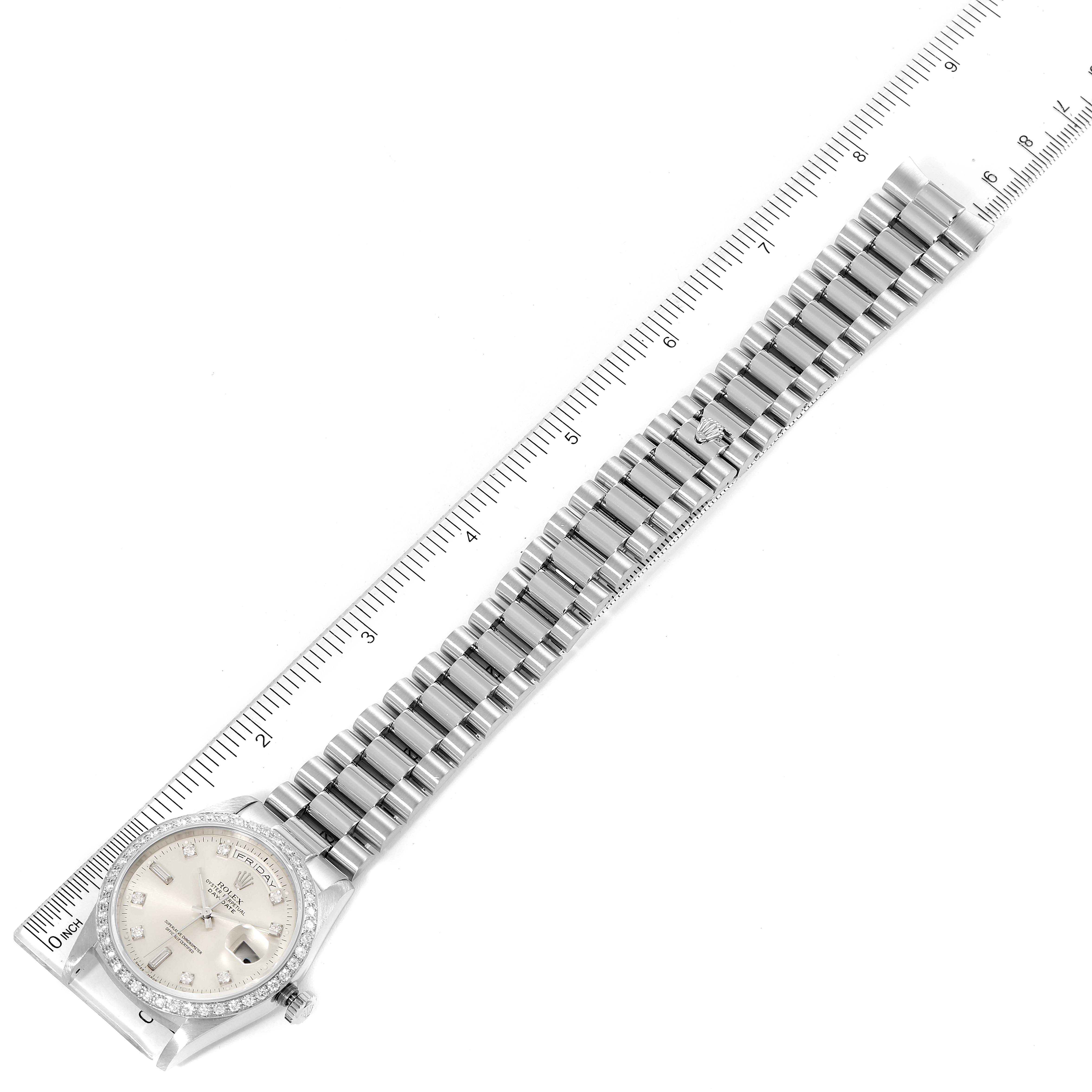 The Rolex President 18346 Men's Platinum Silver Dial 18346 Men's Platinum Silver Dial watch is shown from a top-down angle, displaying its face, bezel, and metal bracelet alongside a measuring ruler.