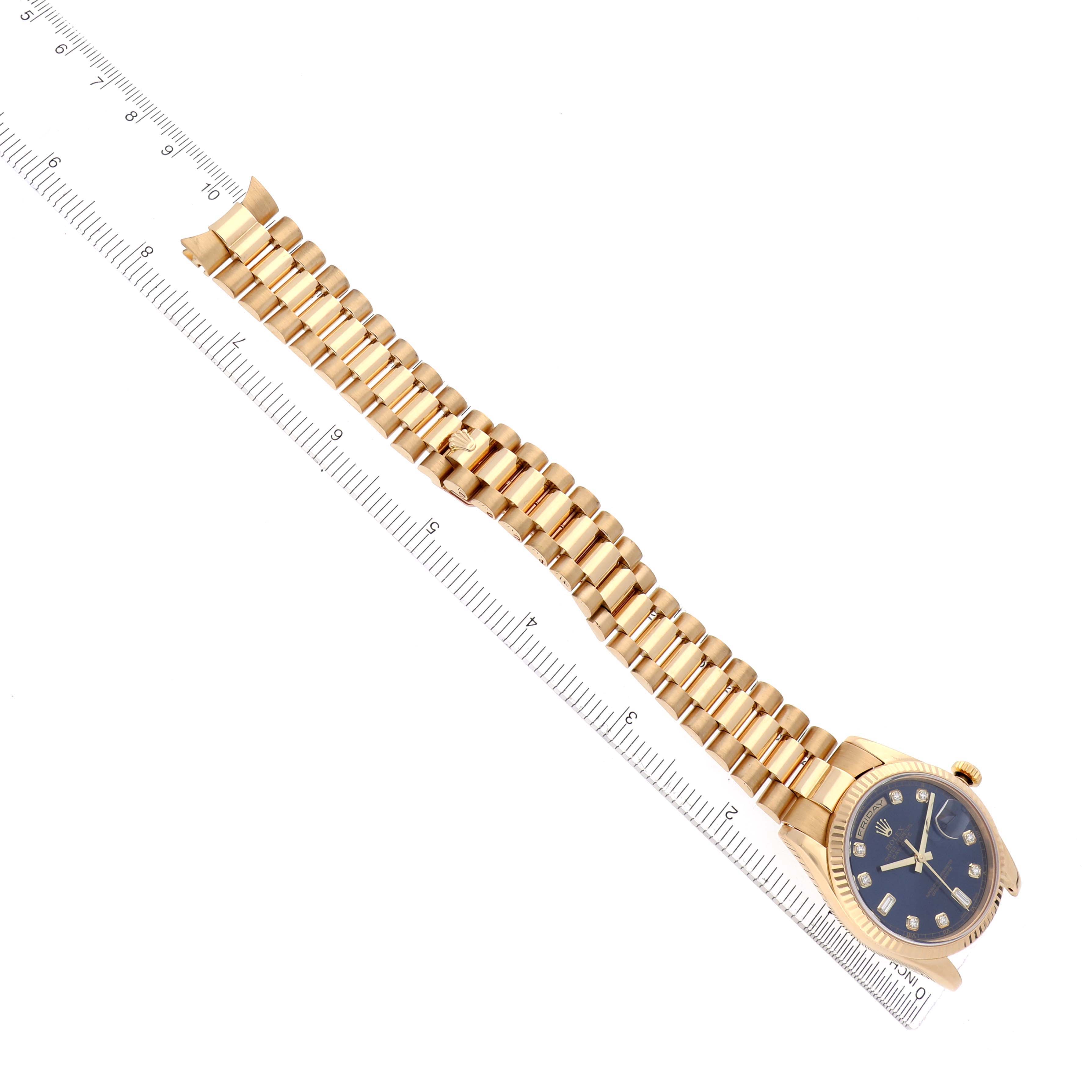 The Rolex President 118238 Men
s Yellow Gold Blue Dial 118238 Men
s Yellow Gold Blue Dial watch is displayed diagonally, showing the full bracelet, case, and dial alongside a ruler for scale.
