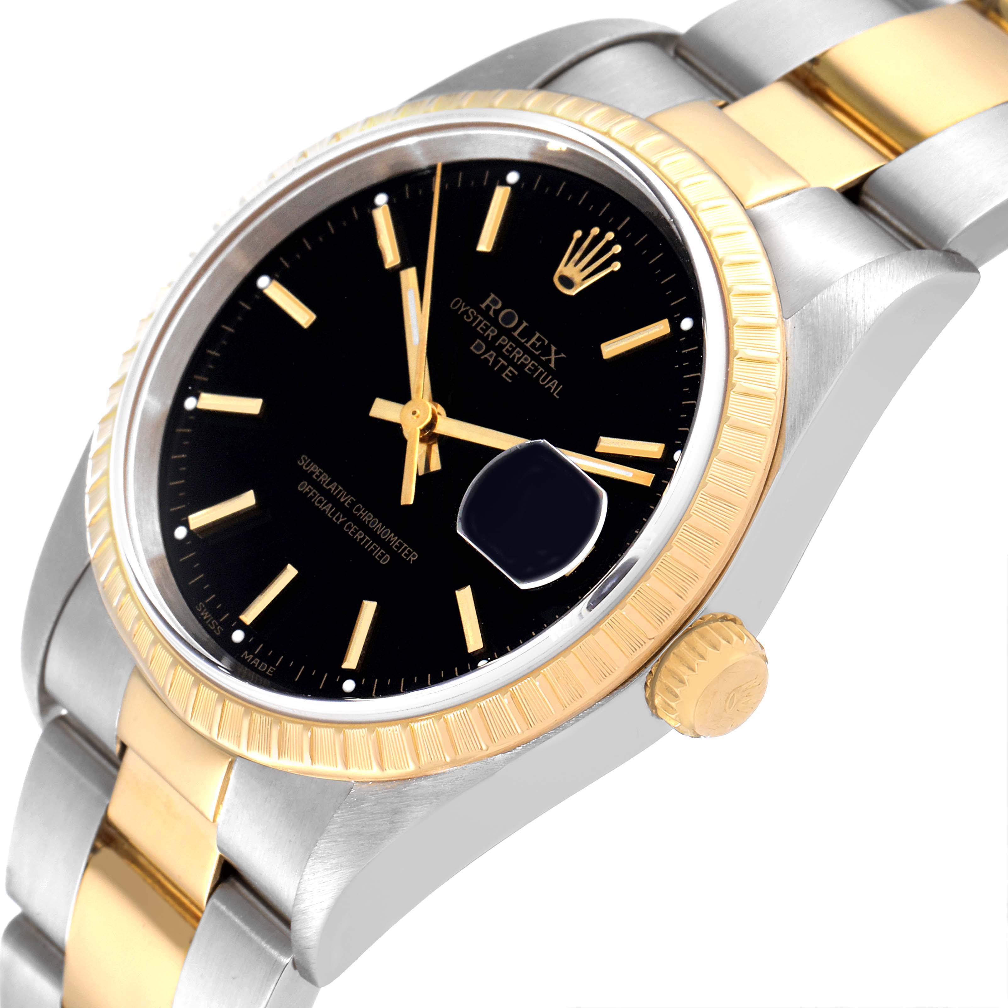 This image shows a Rolex Oyster Perpetual Date watch at an angled view, highlighting the black dial, gold fluted bezel, and two-tone bracelet.