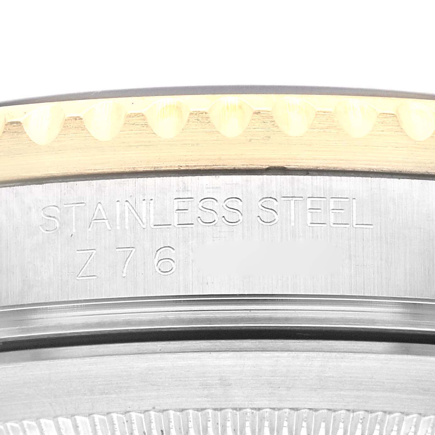 This image shows a close-up of the side of a Rolex Submariner 16613 Men's Steel and Gold (two tone) Black Dial 16613 Men's Steel and Gold (two tone) Black Dial model, revealing part of the bezel and engraved text on the case.