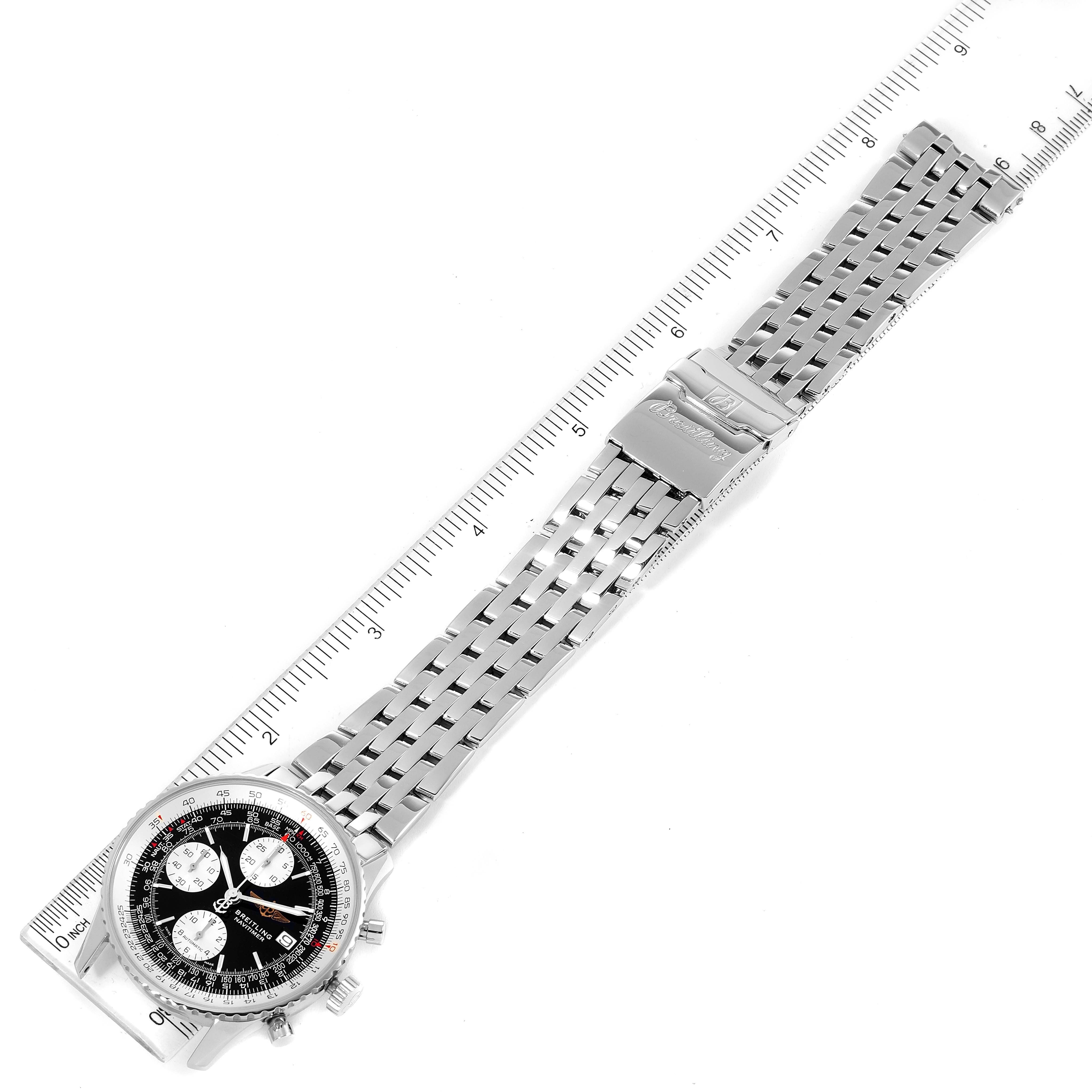 The image shows a top-down view of a Breitling Navitimer A13322 Men
s Stainless Steel Black Dial A13322 Men
s Stainless Steel Black Dial watch with a metal band and clasp, including a ruler for scale.