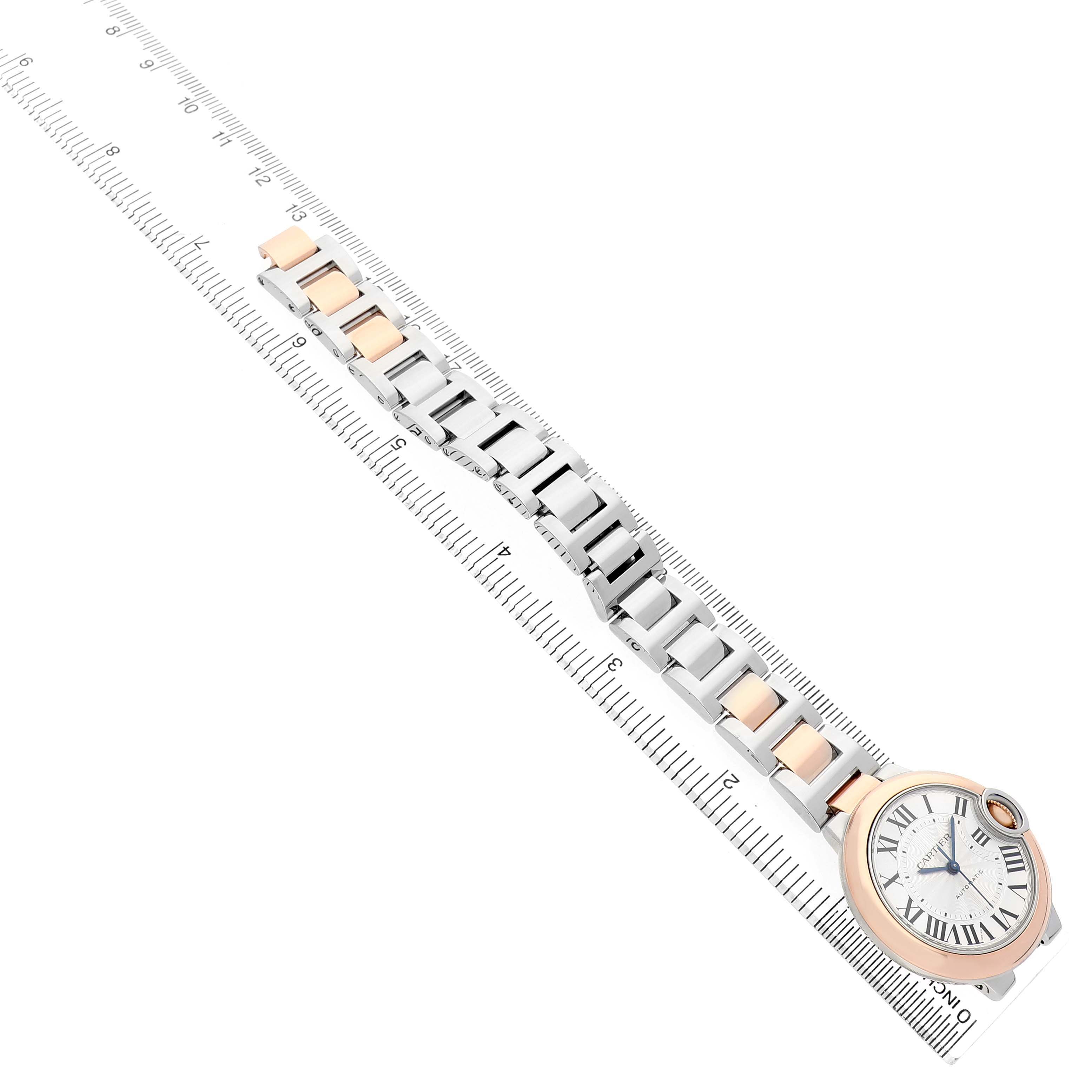 The Cartier Ballon Bleu W2BB0023 Women's Stainless Steel Silver Dial watch is shown at an oblique angle with its full bracelet and dial visible, alongside a ruler for scale.