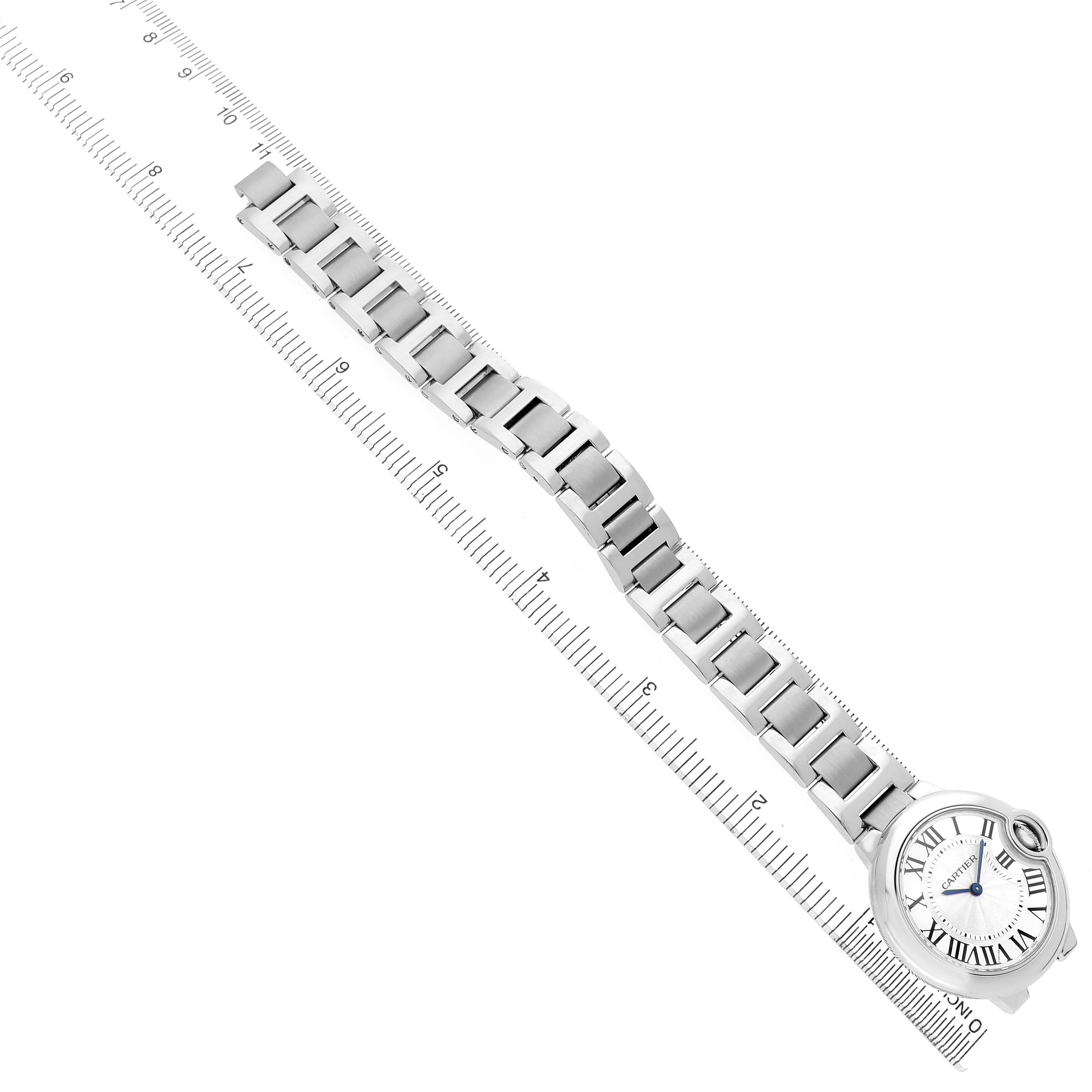 The Cartier Ballon Bleu W6920084 Women's Stainless Steel Silver Dial watch is shown flat, displaying its face, metal strap, and side view with a ruler underneath for scale.