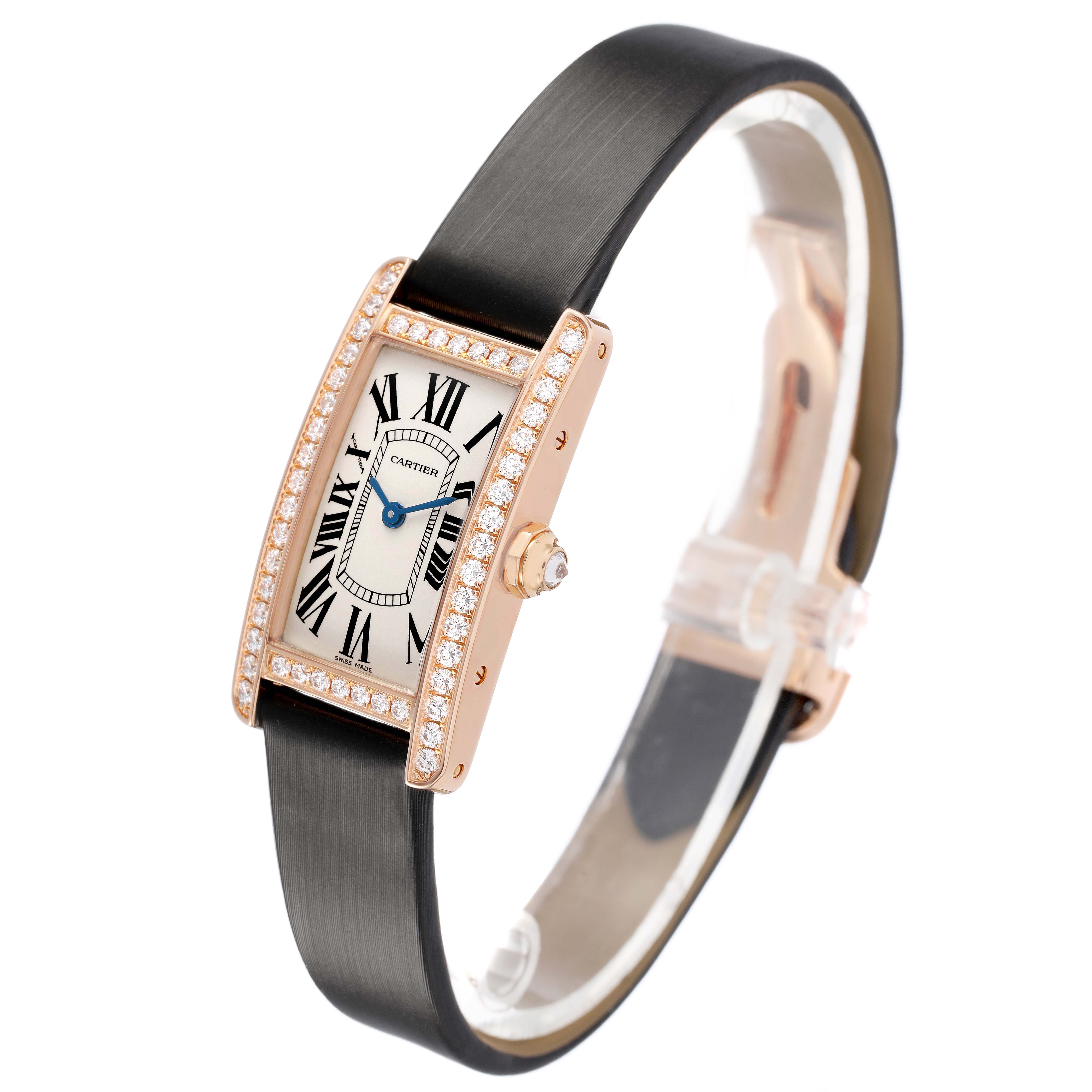The Cartier Tank Americaine WJTA0002 Women's Rose Gold Silver Dial watch is shown at a three-quarter angle, highlighting the diamond-studded case, dial, and black strap.