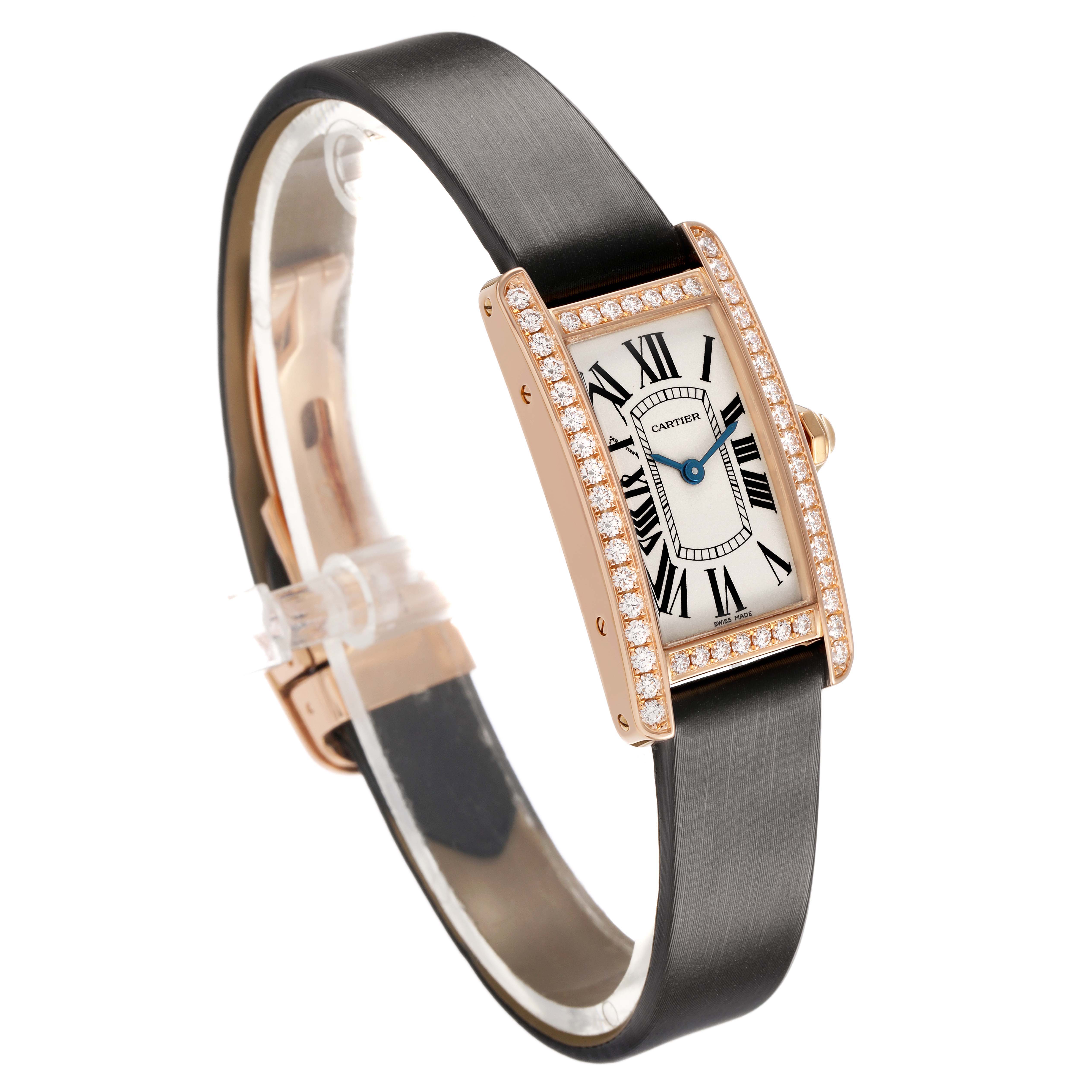 The Cartier Tank Americaine WJTA0002 Women's Rose Gold Silver Dial watch is shown at an angle highlighting its elegant face, diamond-set bezel, and black strap.