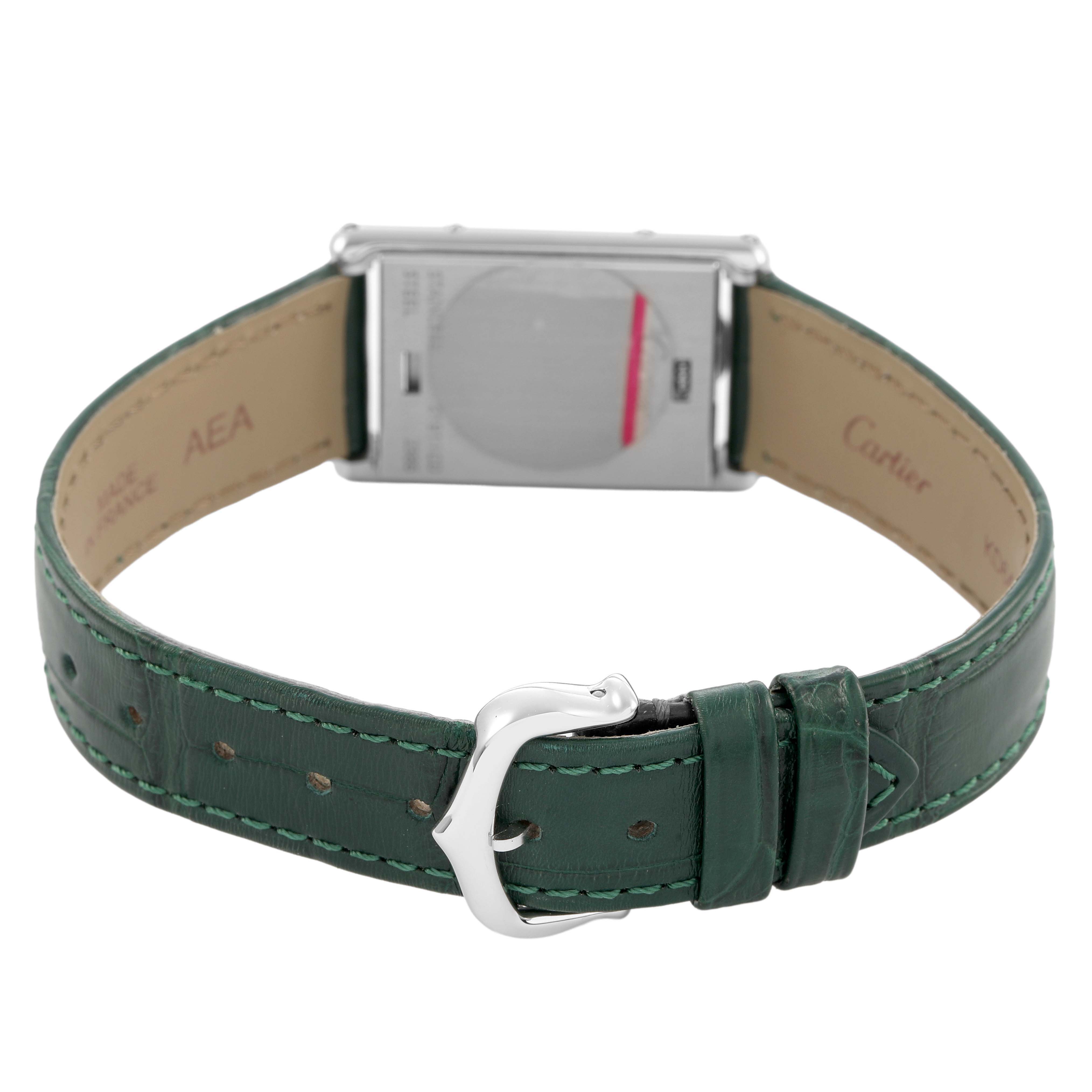 The image shows the back of a Cartier Tank Basculante W1011158 Women's Stainless Steel Silver Dial watch with a green leather strap and a silver buckle.