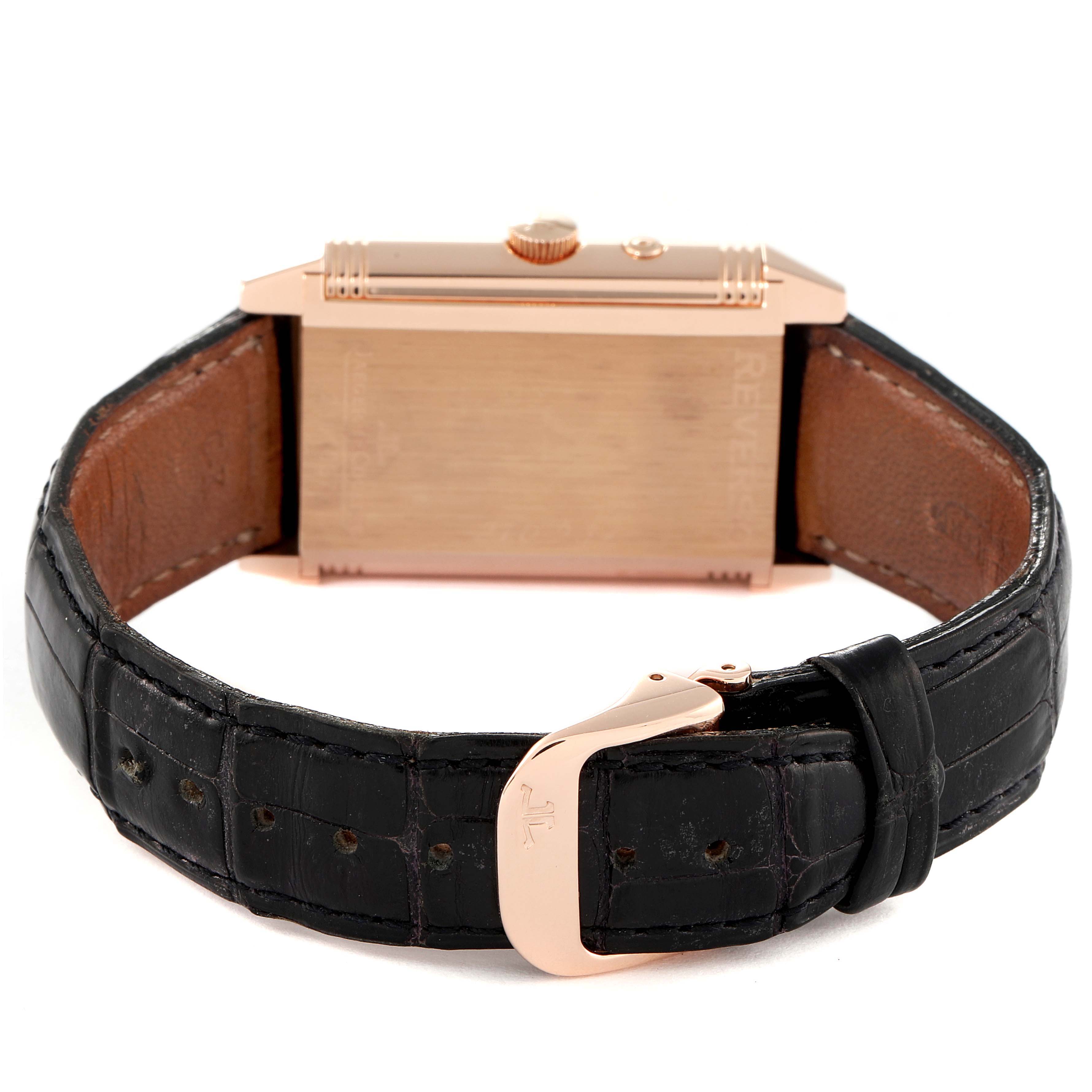 The image shows the backside and strap of a Reverso model by Jaeger LeCoultre, featuring a gold case and a black leather strap.