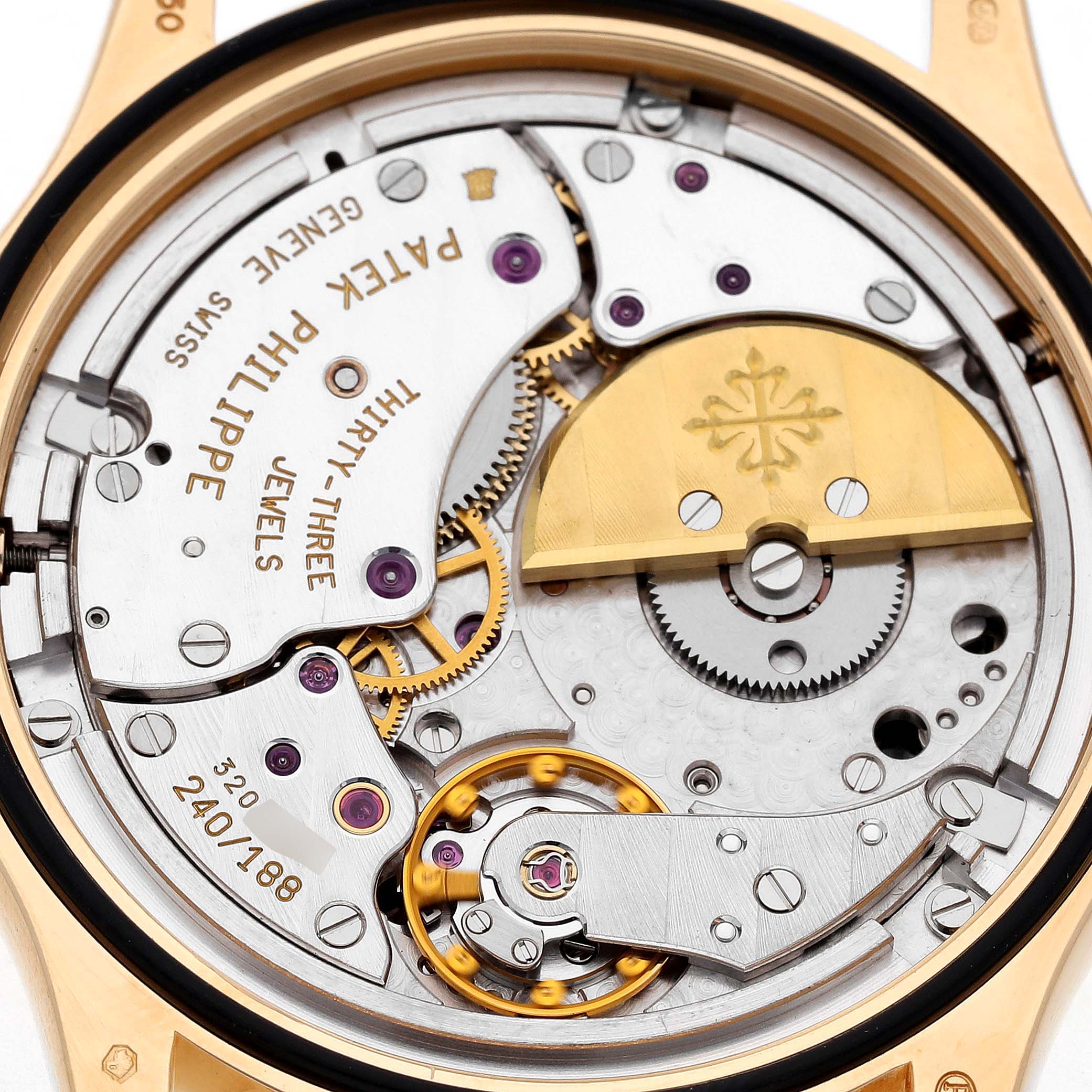 The image shows the movement of a Patek Philippe Complications 5110J-001 Men's Yellow Gold Silver Dial watch, highlighting gears and the rotor from a rear angle.