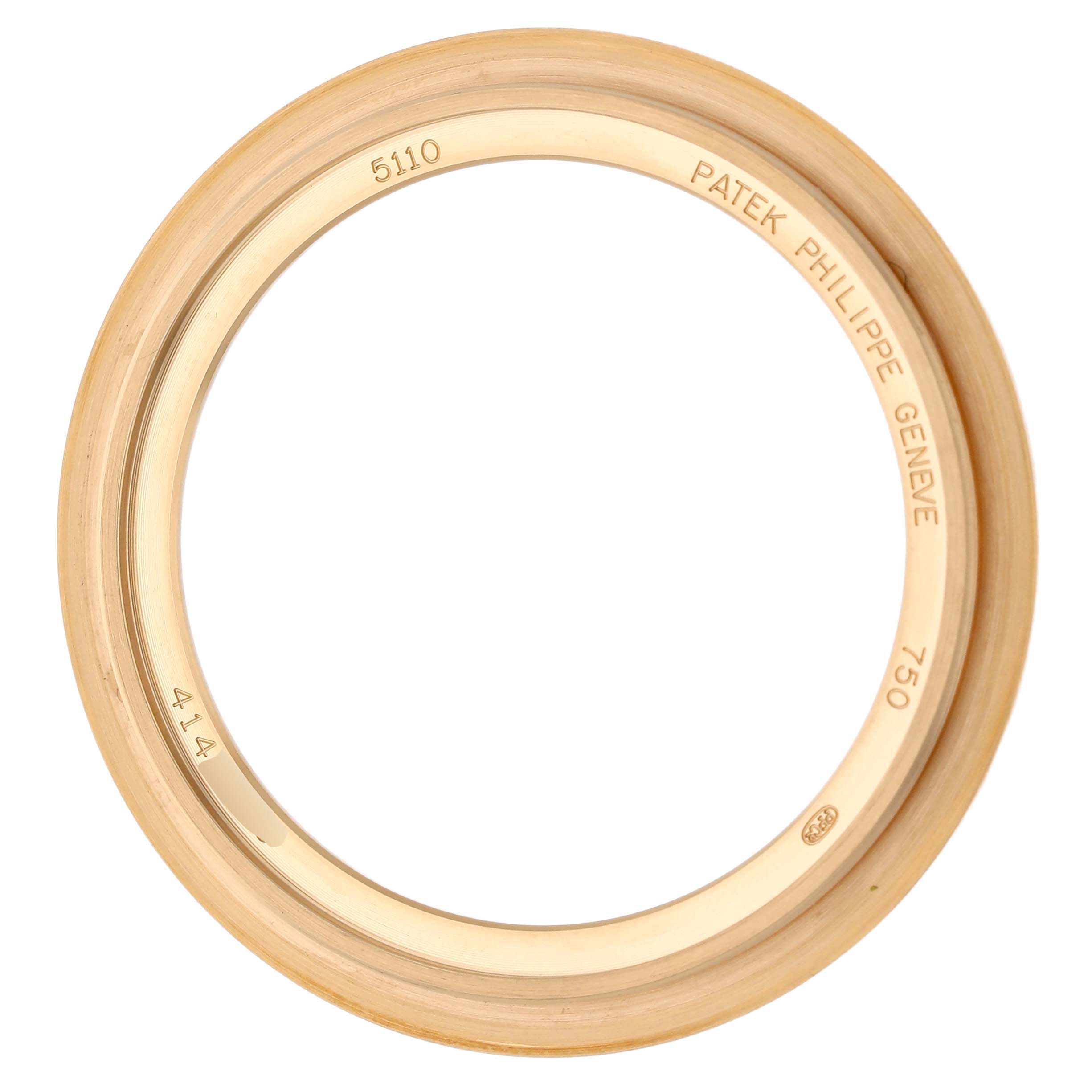 This image shows the bezel of a Patek Philippe Complications 5110J-001 Men's Yellow Gold Silver Dial watch, viewed from above, featuring engravings and gold detailing.