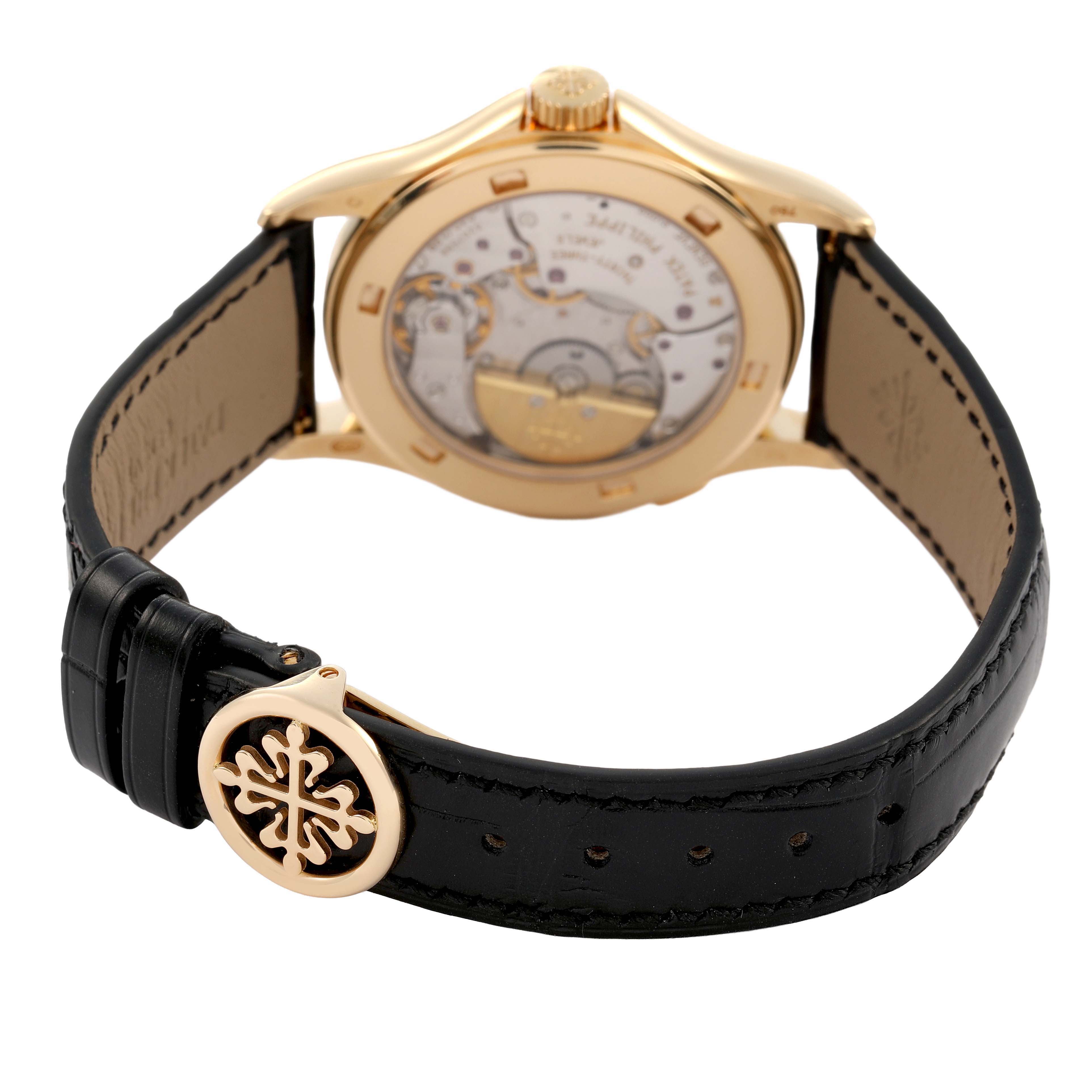 The image shows the back of a Patek Philippe Complications 5110J-001 Men's Yellow Gold Silver Dial watch, highlighting its movement and black strap with buckle.
