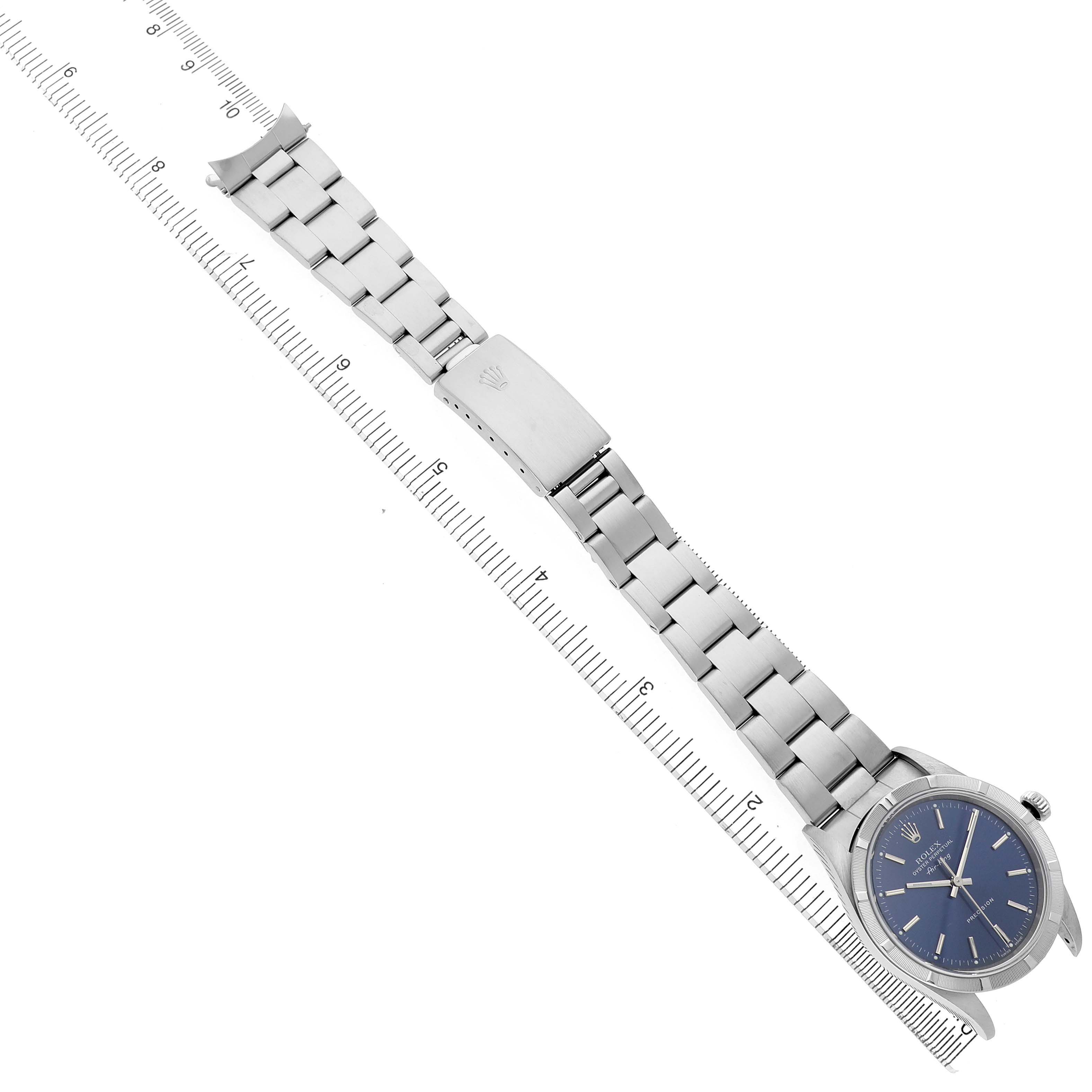 The Rolex Air-King 14010 Men's Stainless Steel Blue Dial watch is shown flat at an angle with its band extended beside a measuring ruler.