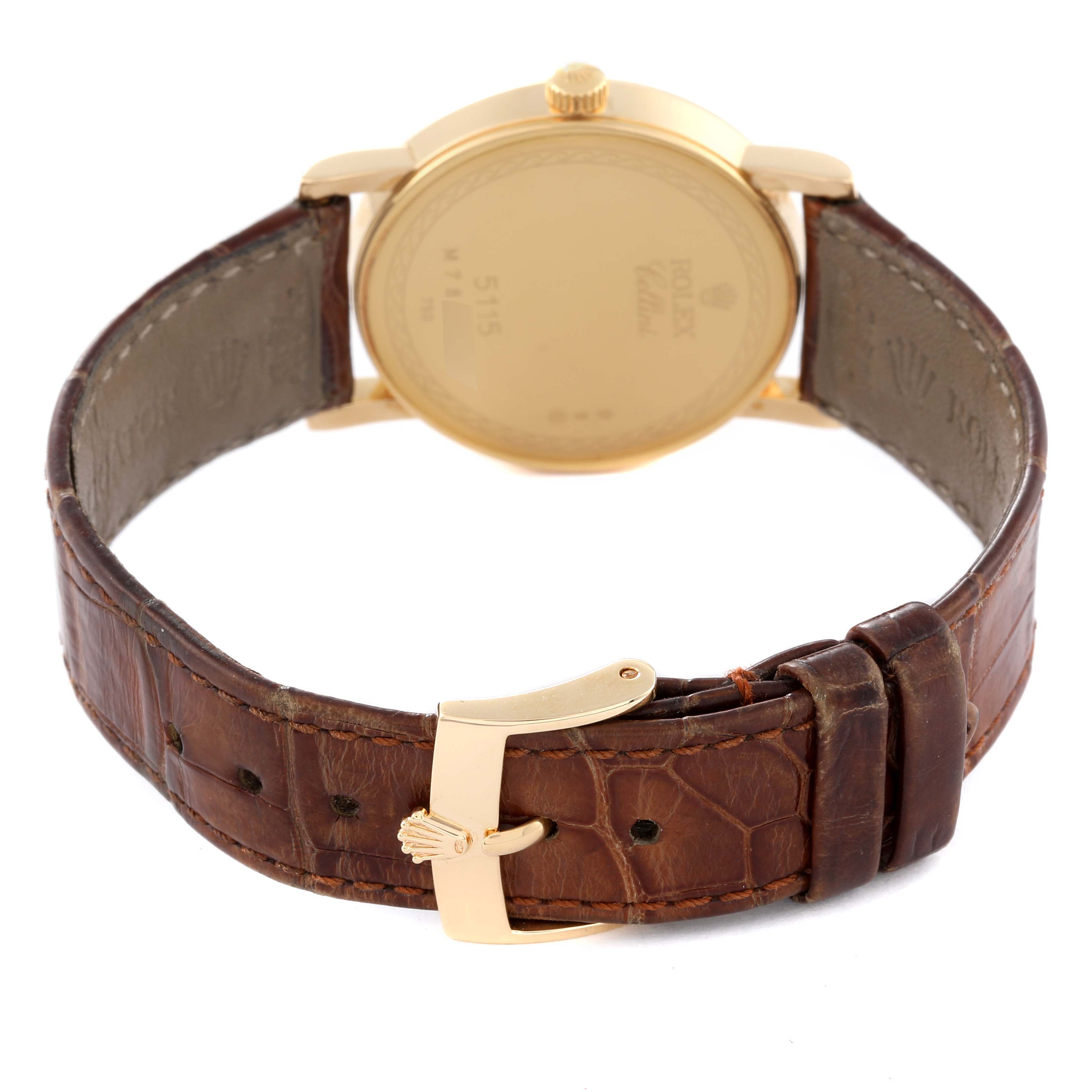 The image shows the back view of a Rolex Cellini 5115 Men's Yellow Gold Champagne Dial 5115 Men's Yellow Gold Champagne Dial watch, focusing on its gold case, leather strap, and buckle.