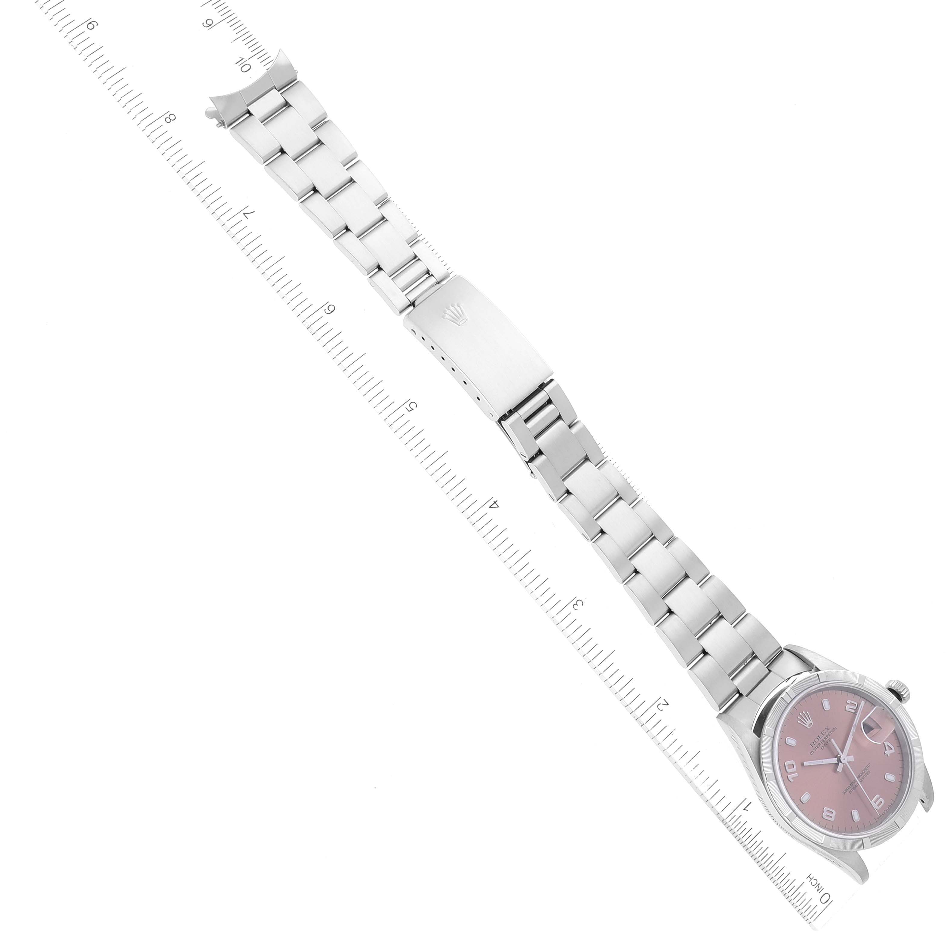 The image shows a Rolex Date 15210 Men's Stainless Steel Pink Dial 15210 Men's Stainless Steel Pink Dial model watch laid flat with its bracelet stretched alongside a ruler.