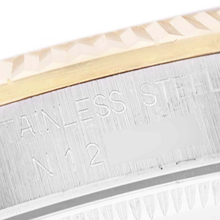 This close-up image shows the side of a mid-size Rolex watch case, featuring "STAINLESS STEEL" engraving.