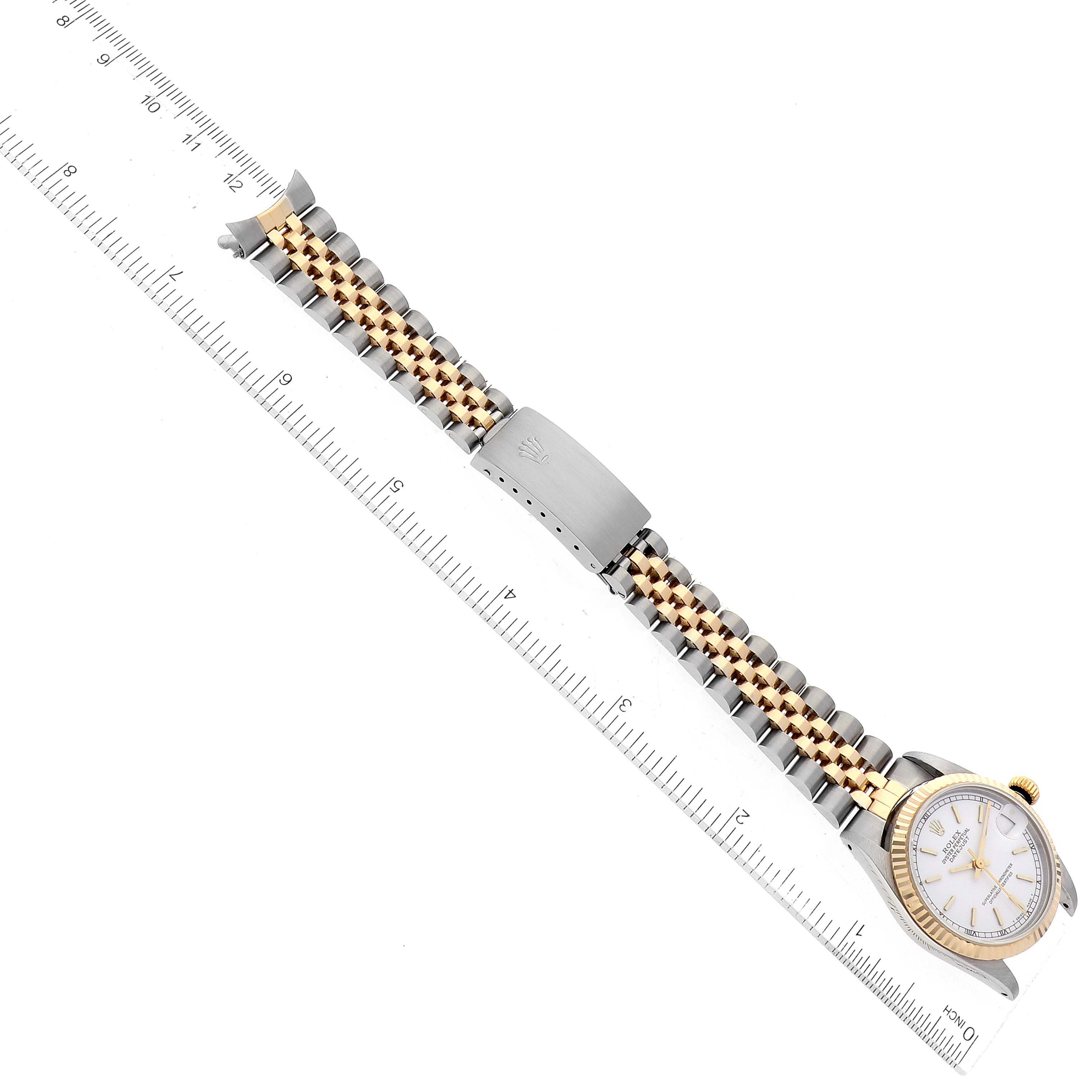 The image shows a top-down view of a Rolex Mid-Size 68273 Women's Steel and Gold (two tone) Champagne Dial 68273 Women's Steel and Gold (two tone) Champagne Dial model watch with a two-tone metal bracelet and a ruler for scale.