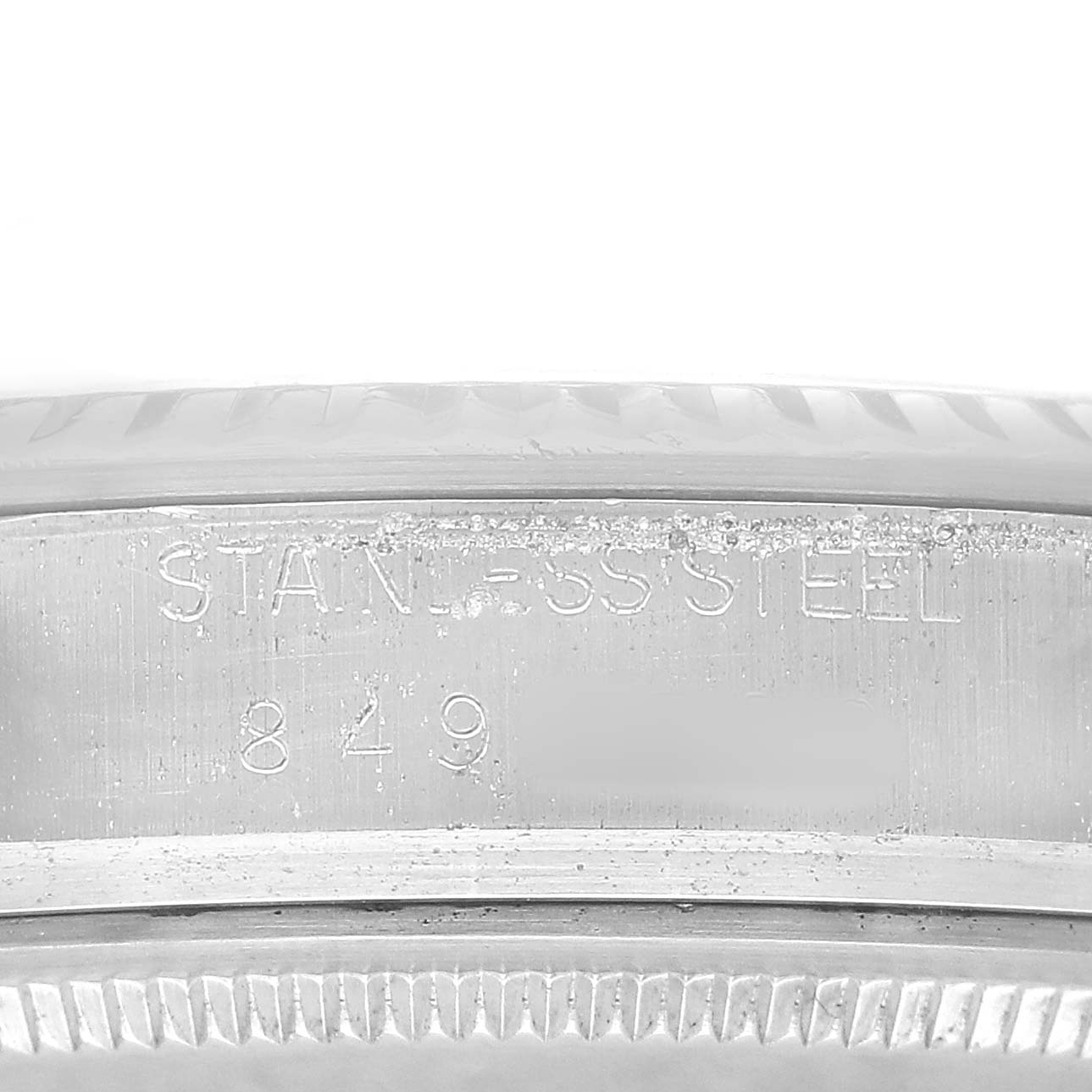 The image shows a close-up of the side of a Rolex Vintage Collection 16014 Men's Stainless Steel Silver Dial watch, highlighting the "STAINLESS STEEL" engraving and edge details.