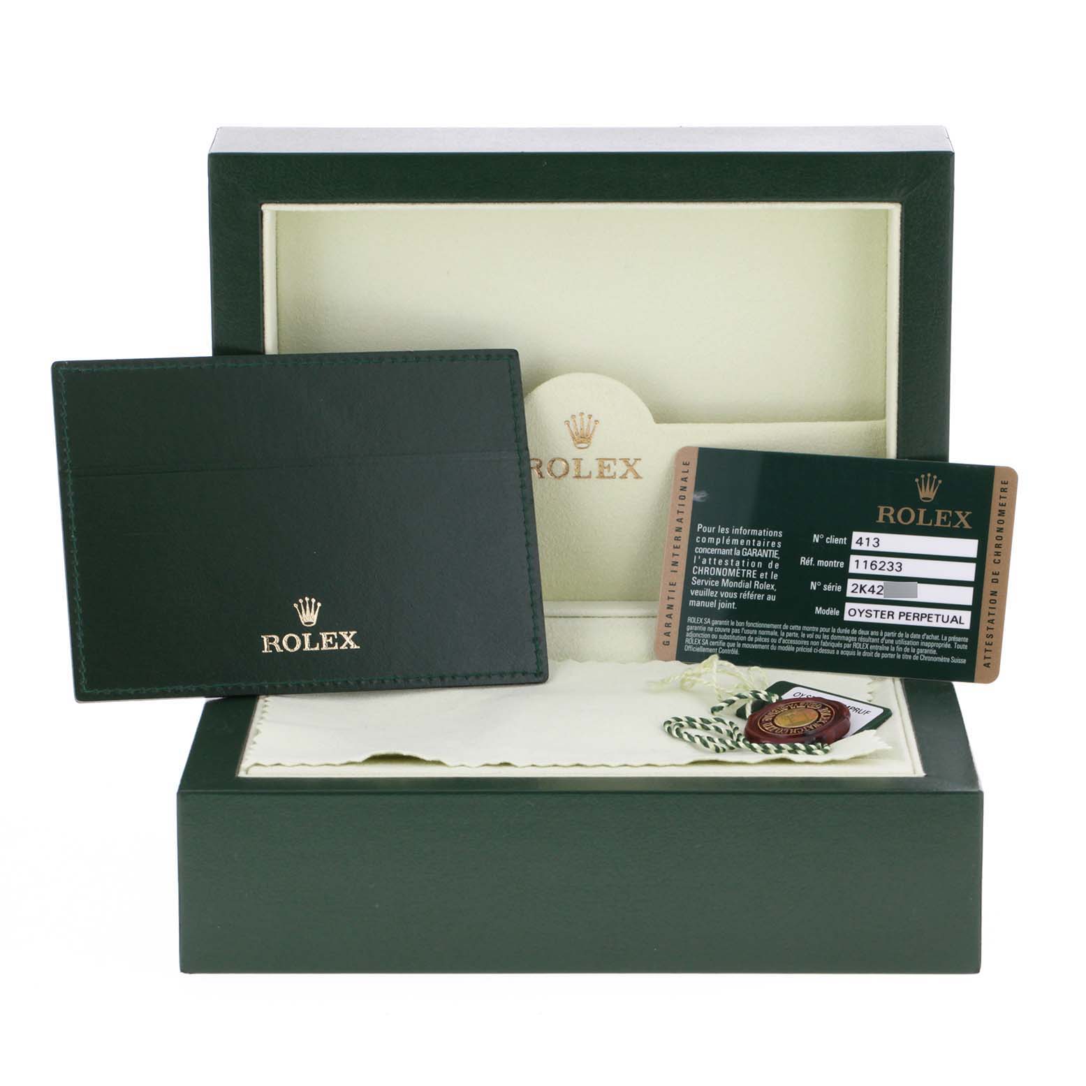 The image shows the packaging of a Rolex Datejust 116233 Men's Steel and Gold (two tone) Champagne Dial 116233 Men's Steel and Gold (two tone) Champagne Dial, including its green box, warranty card, cardholder, and a seal.