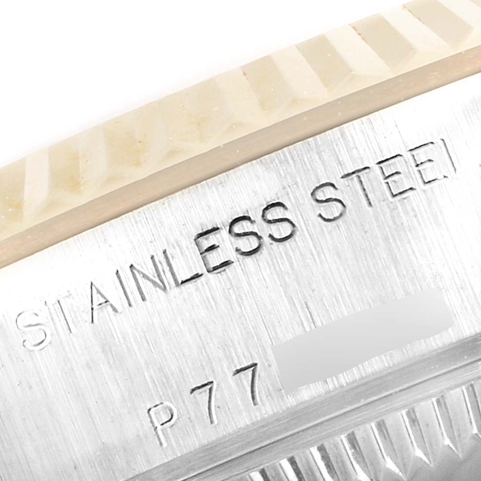 This close-up image shows the fluted bezel and part of the case back of a Rolex Datejust 79173 Women
s Steel and Gold (two tone) Mother of Pearl Dial 79173 Women
s Steel and Gold (two tone) Mother of Pearl Dial watch with "STAINLESS STEEL" engraved.