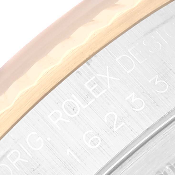 The image shows a close-up of the case back edge of the Rolex Datejust 16233 Men's Steel and Gold (two tone) Silver Dial 16233 Men's Steel and Gold (two tone) Silver Dial, featuring part of the engravings and the gold bezel.