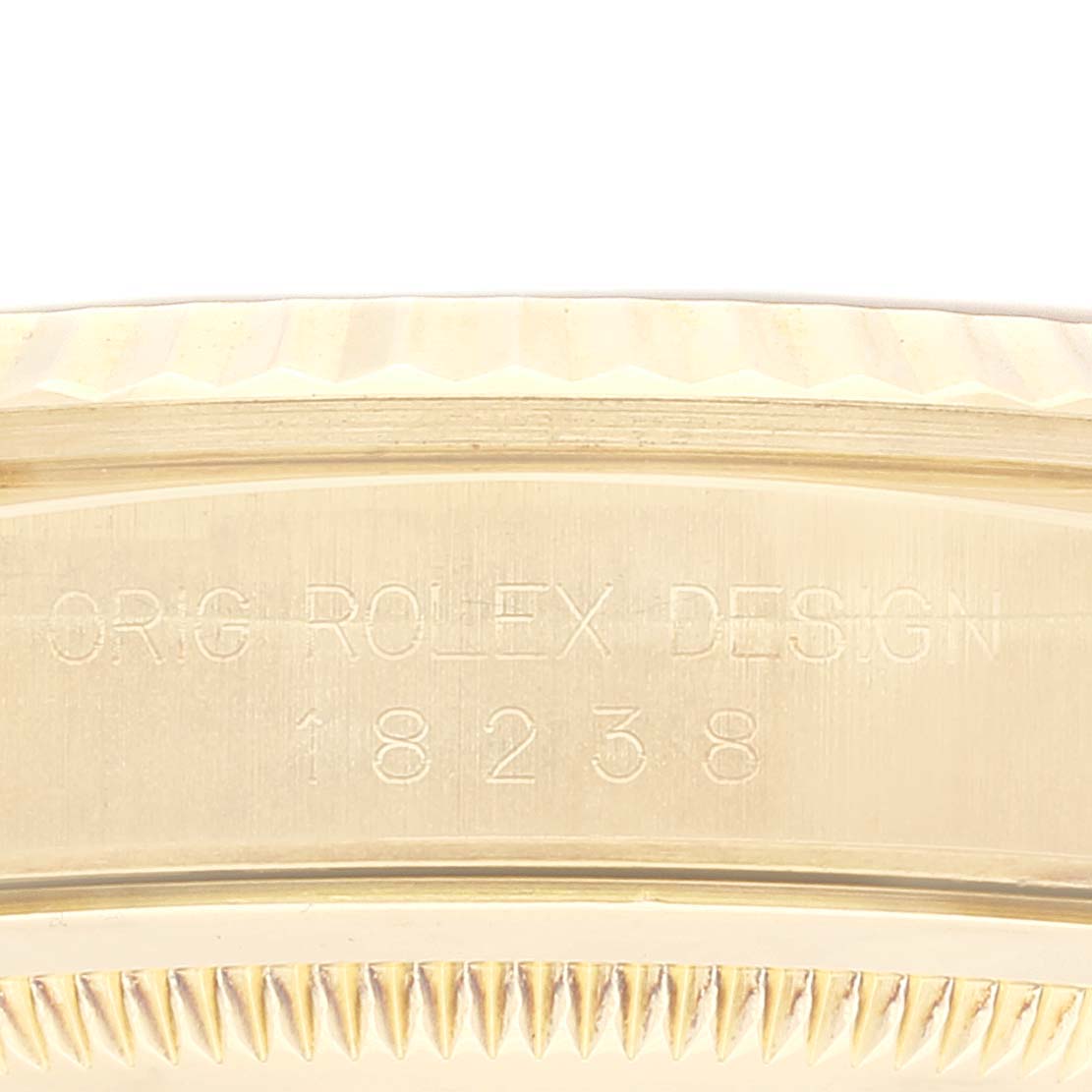 The image shows a close-up of the case edge for a Rolex President 18238 Men's Yellow Gold Champagne Dial 18238 Men's Yellow Gold Champagne Dial model watch, highlighting its carved "ORIG ROLEX DESIGN 18238" inscription.