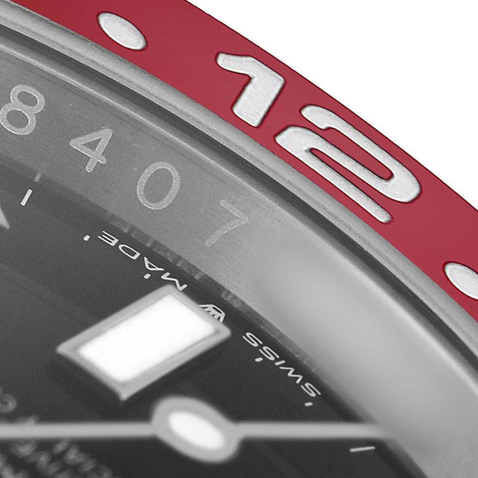 The image shows a close-up view of the Rolex GMT-Master 126710BLRO Men's Stainless Steel Black Dial's bezel, focusing on the red portion with numerals and part of the dial.