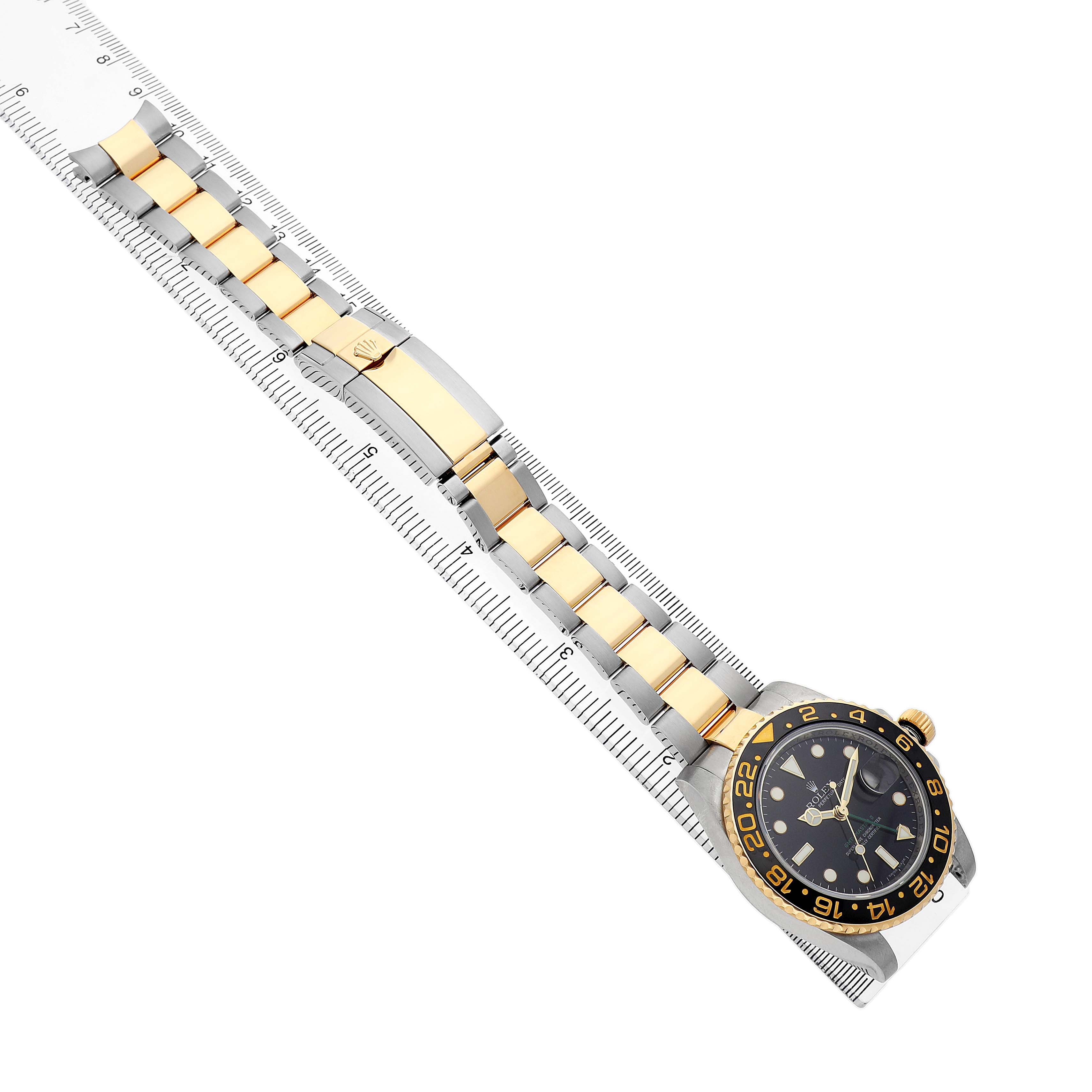 The Rolex GMT-Master 116713LN Men's Stainless Steel Black Dial watch is displayed diagonally, showing its full bracelet, bezel, and dial on a measuring scale.