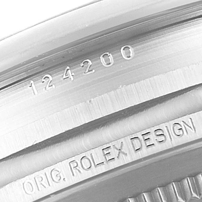 The image shows a close-up of the case edge of a Rolex Oyster Perpetual 124200 Men's Stainless Steel Silver Dial 124200 Men's Stainless Steel Silver Dial watch, highlighting the model number and "Orig. Rolex Design" engraving.