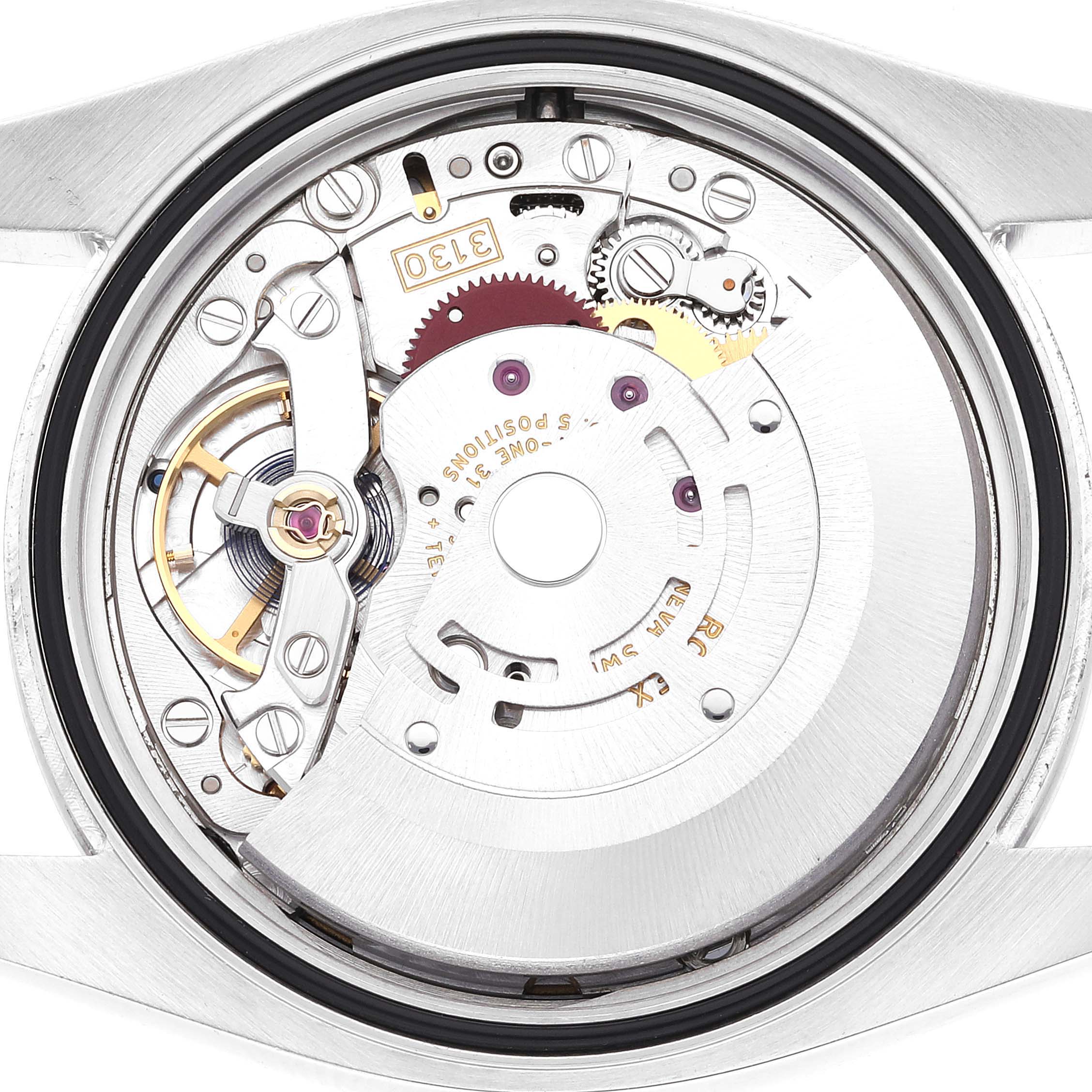 The image shows the internal mechanics and movement of a Rolex Oyster Perpetual 116000 Men's Stainless Steel Black Dial 116000 Men's Stainless Steel Black Dial watch from the back angle, revealing the intricate gears and parts.