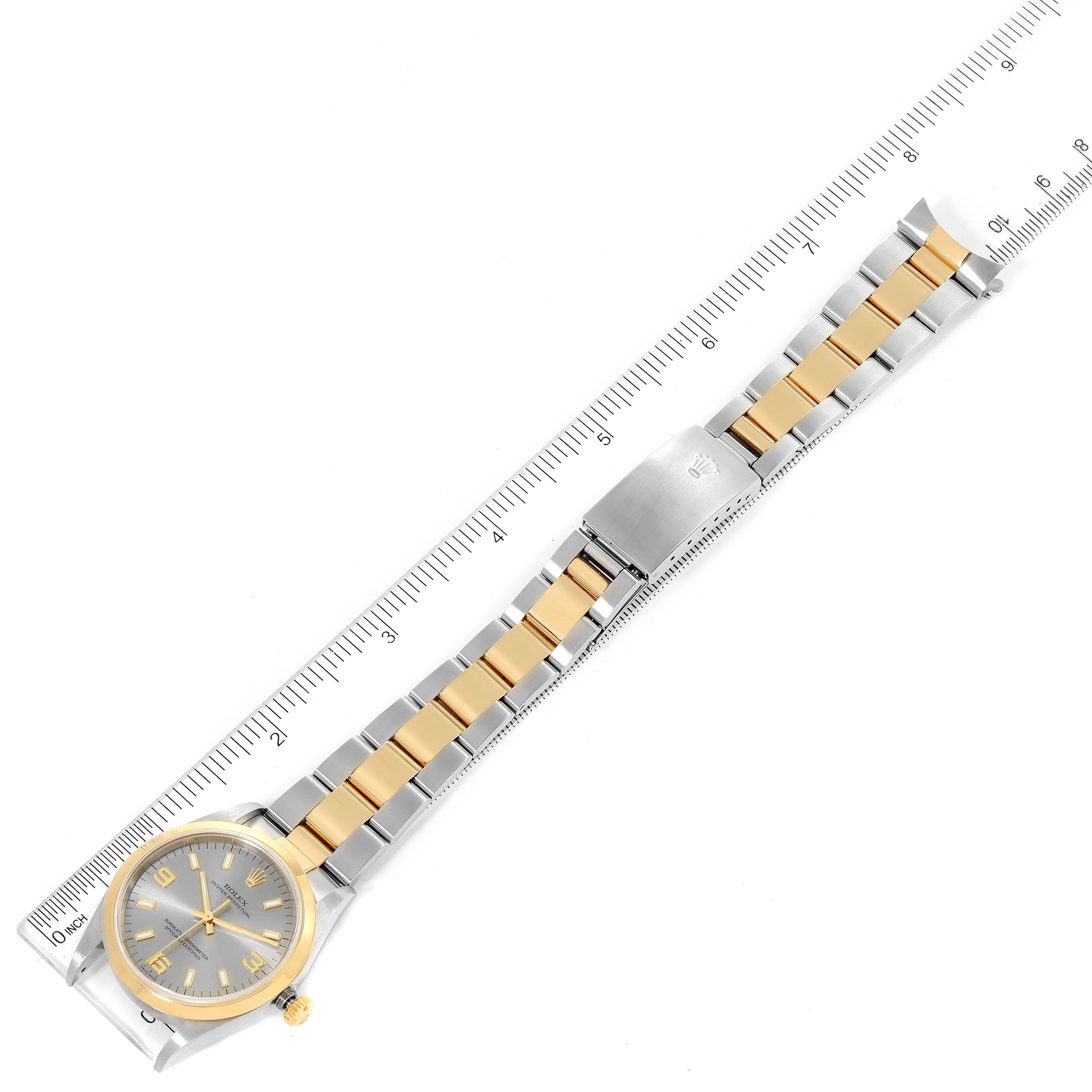 The image shows a top-down view of a Rolex Oyster Perpetual 14203 Men's Steel and Gold (two tone) Grey Dial 14203 Men's Steel and Gold (two tone) Grey Dial watch with a metal bracelet beside a ruler.