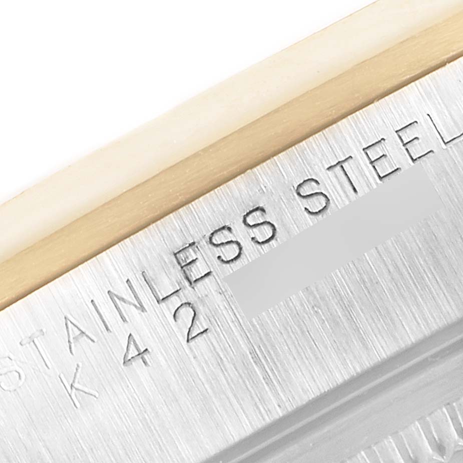 This close-up image shows the engraved text on the stainless steel case of a Rolex Oyster Perpetual 14203 Men's Steel and Gold (two tone) Grey Dial 14203 Men's Steel and Gold (two tone) Grey Dial watch.