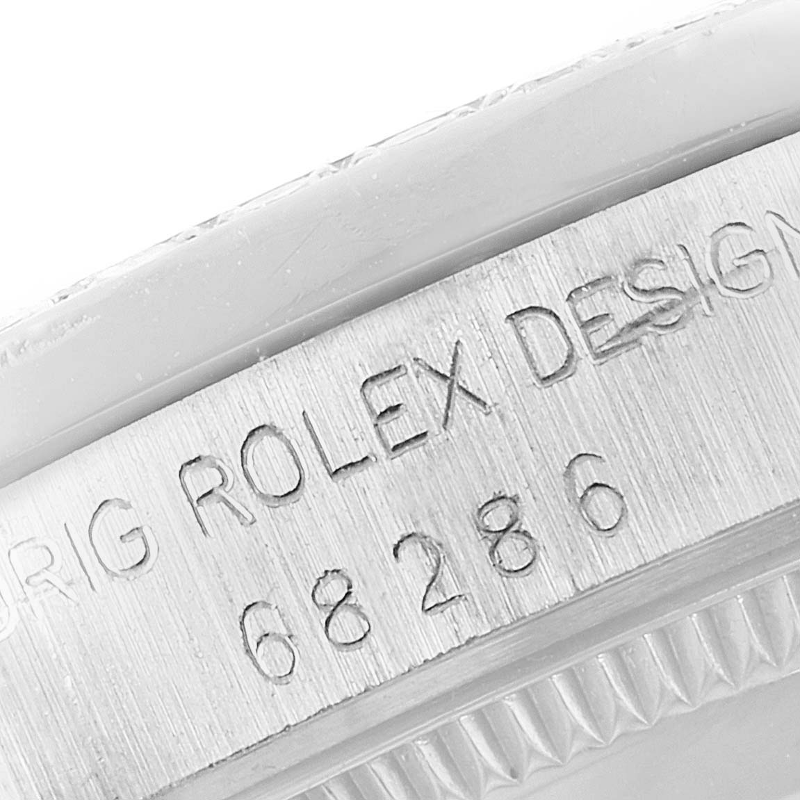 This image shows a close-up of the edge of a Rolex President 68286 Women's Platinum Silver Dial 68286 Women's Platinum Silver Dial model watch with "Orig Rolex Design" and a serial number engraved.
