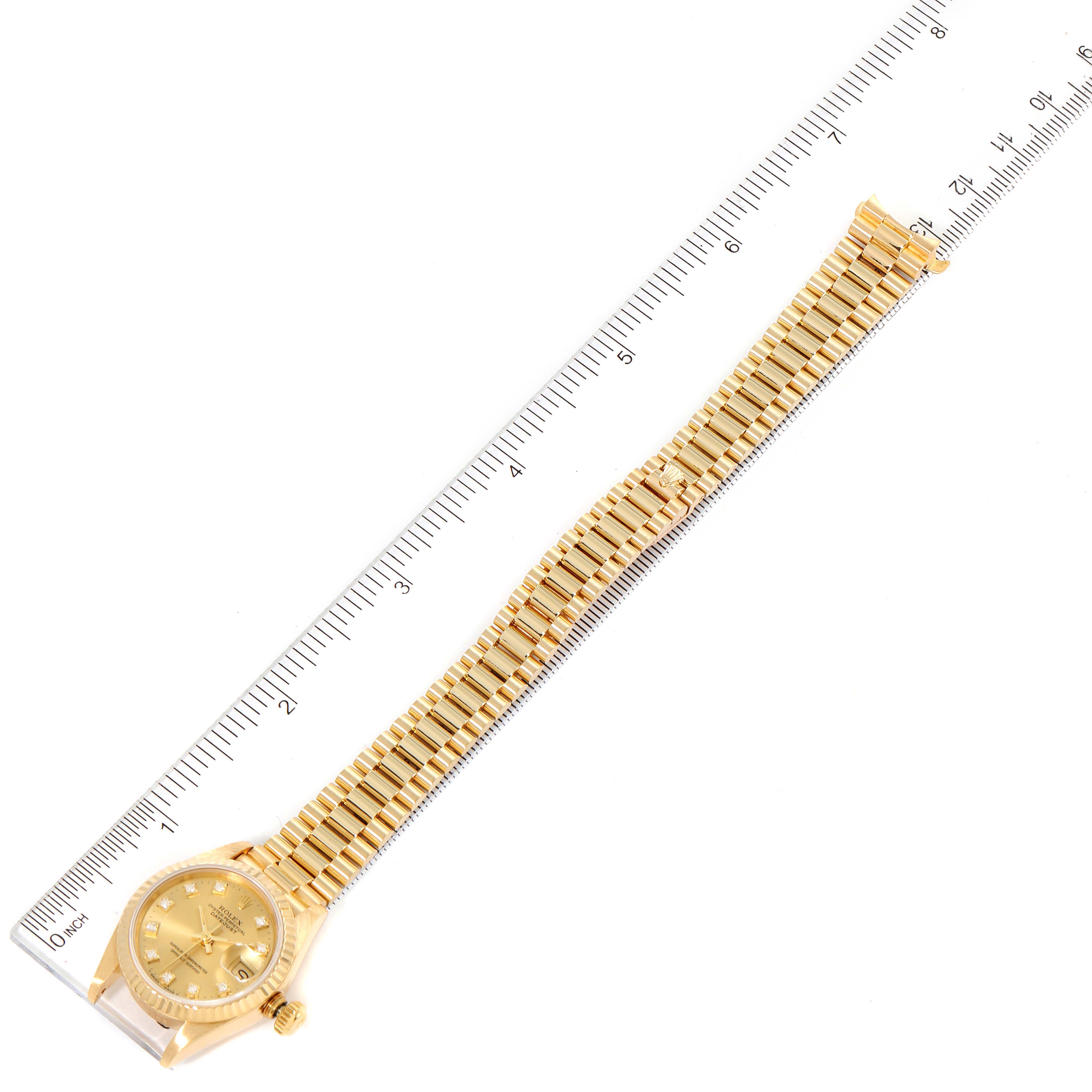 The image shows a full-length view of a Rolex President 69178 Women
s Yellow Gold Champagne Dial 69178 Women
s Yellow Gold Champagne Dial model watch with a ruler for size reference.