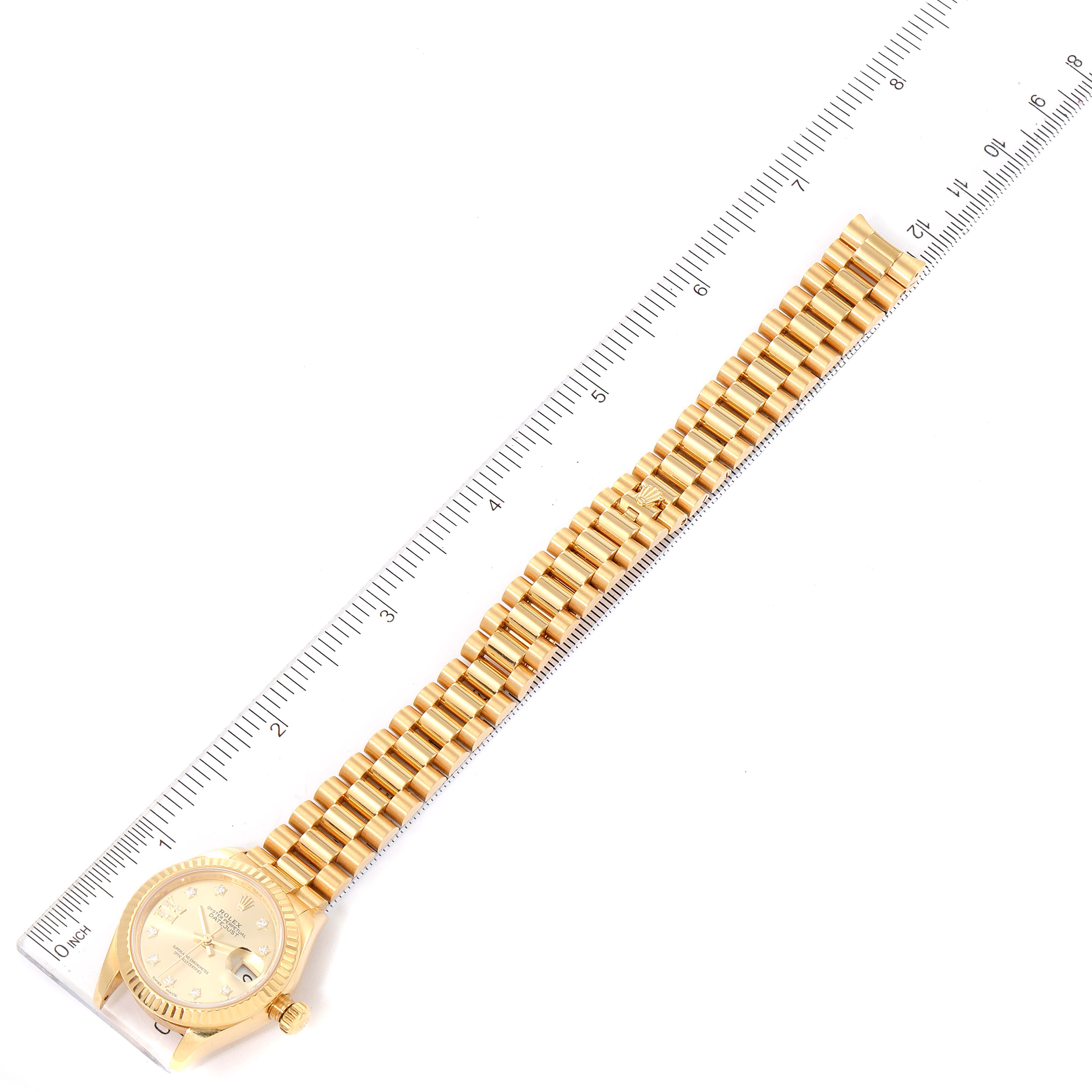 The image shows a Rolex President 279178 Women
s Yellow Gold Champagne Dial 279178 Women
s Yellow Gold Champagne Dial model watch laid flat with a ruler measuring its length.