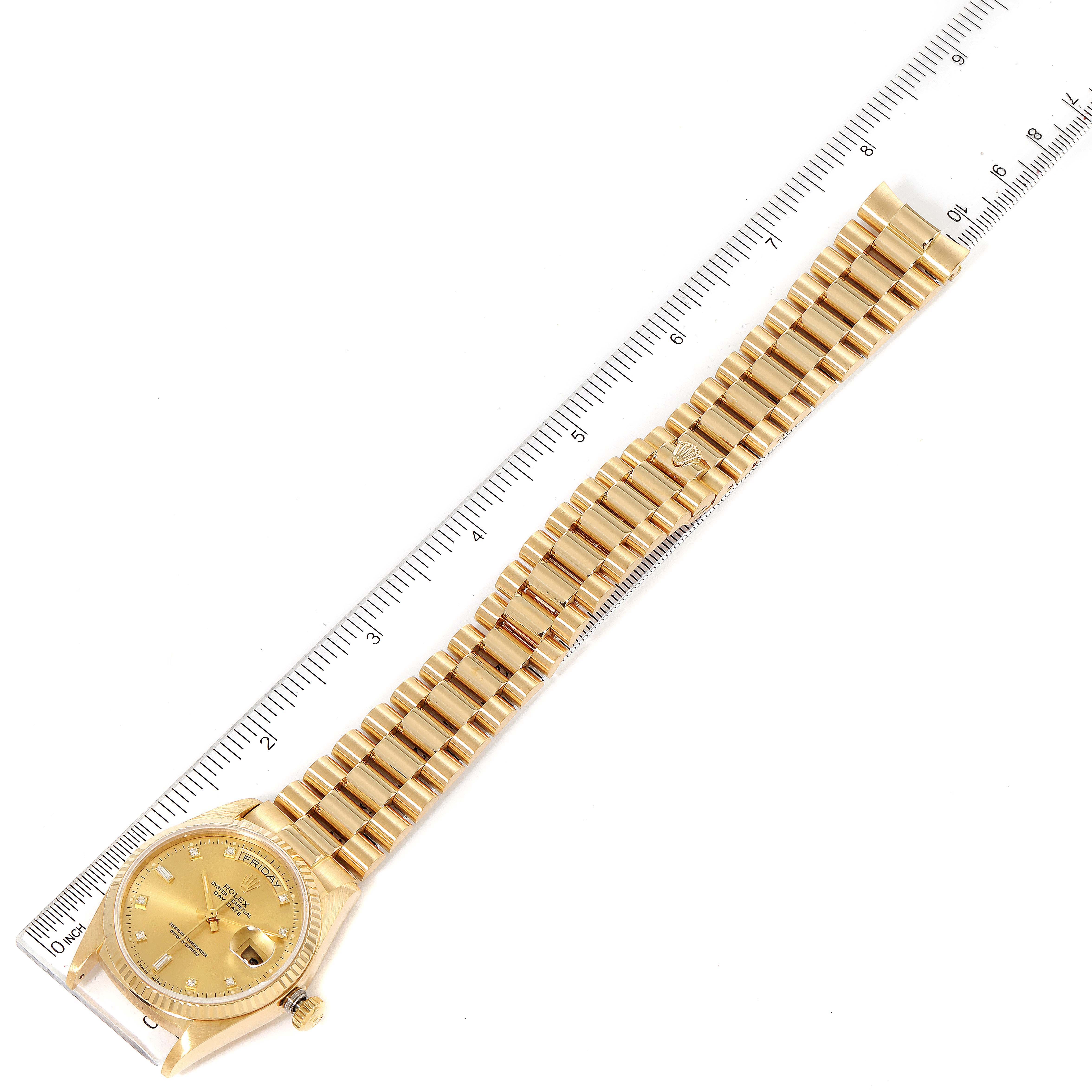 The image shows a top view of a Rolex President 18038 Men's Yellow Gold Champagne Dial 18038 Men's Yellow Gold Champagne Dial model watch, including the watch face and full gold bracelet beside a ruler.