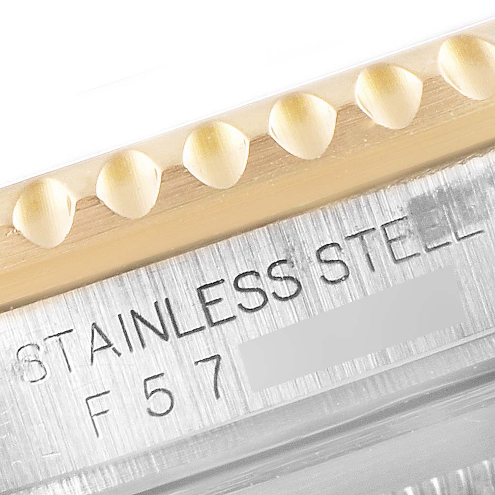 This close-up image shows part of the bezel and case back of a Rolex Submariner 16613 Men's Steel and Gold (two tone) Blue Dial 16613 Men's Steel and Gold (two tone) Blue Dial, highlighting "STAINLESS STEEL" engraving.