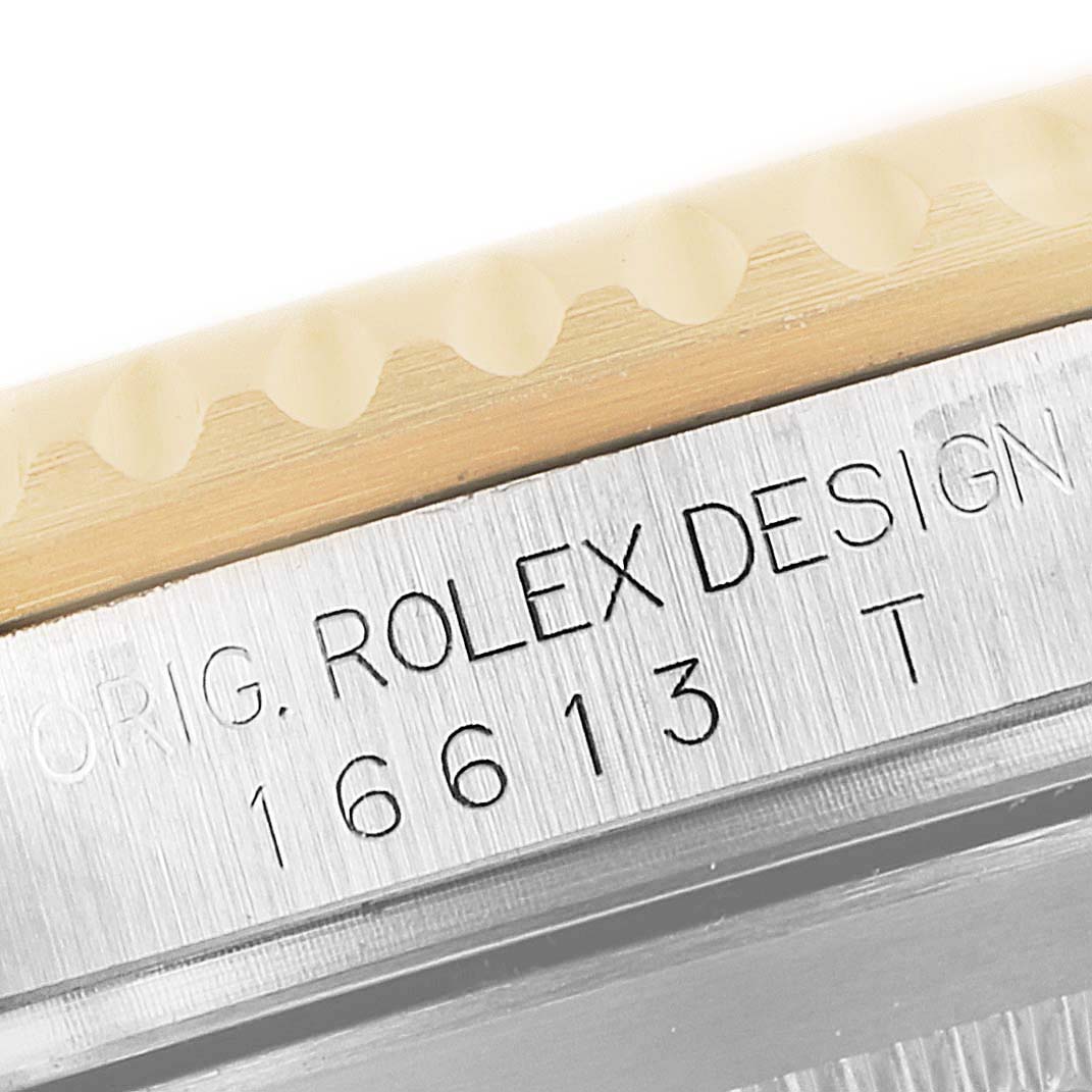 Close-up of the engraved design and model number on a Rolex Submariner 16613 Men's Steel and Gold (two tone) Blue Dial 16613 Men's Steel and Gold (two tone) Blue Dial.