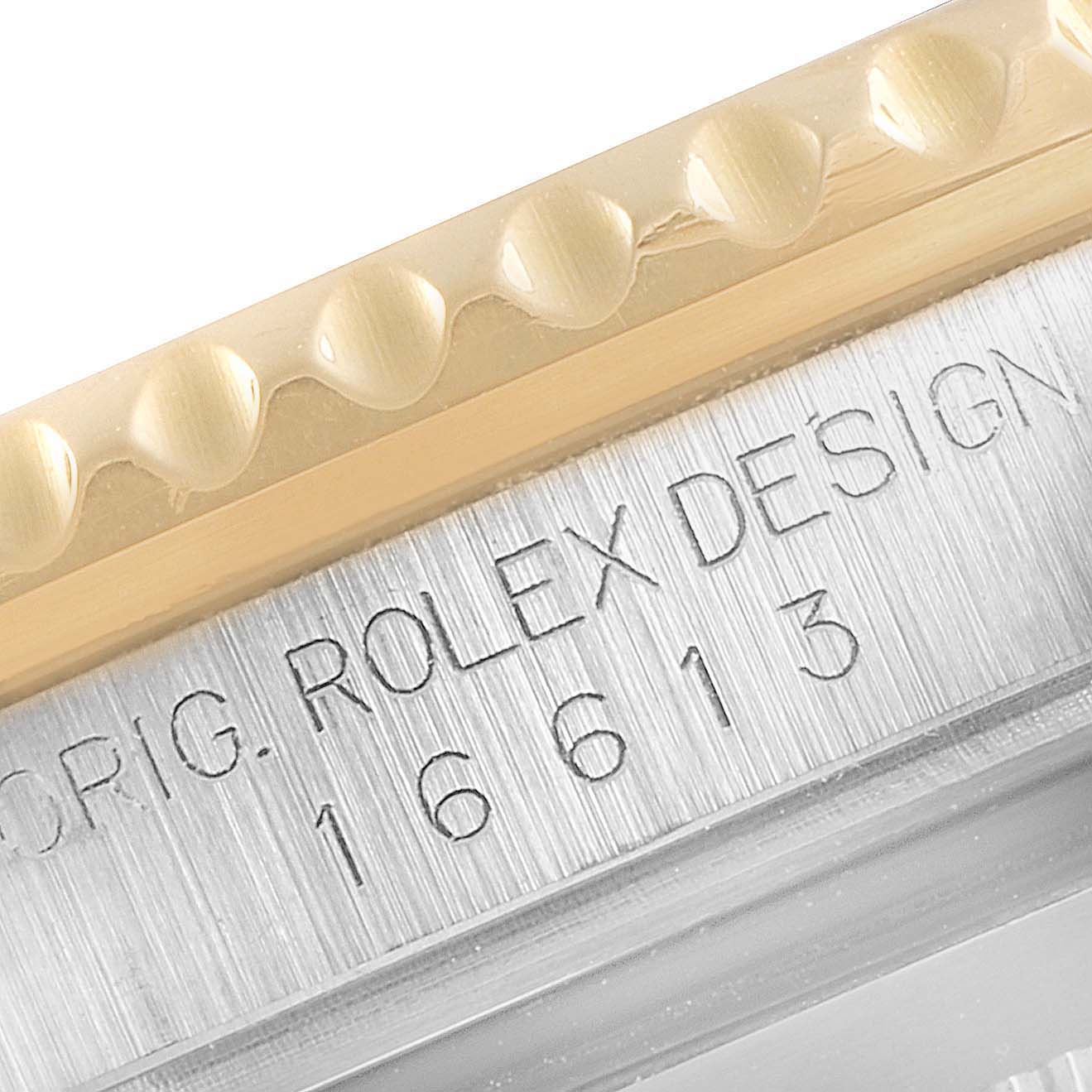 Close-up of the Rolex Submariner 16613 Men
s Steel and Gold (two tone) Blue Dial 16613 Men
s Steel and Gold (two tone) Blue Dial
s model number and knurled bezel edge.